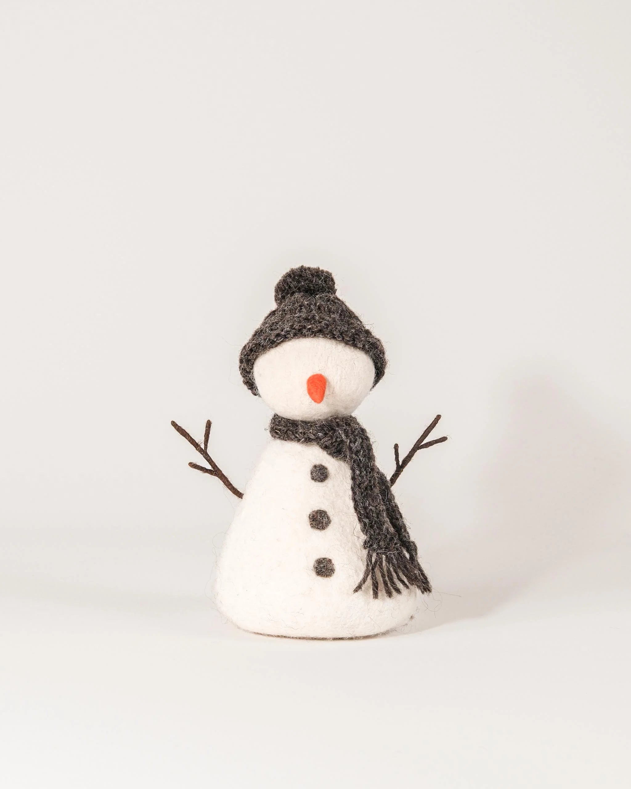 Grand bonhomme de neige en feutrine sur fond blanc.