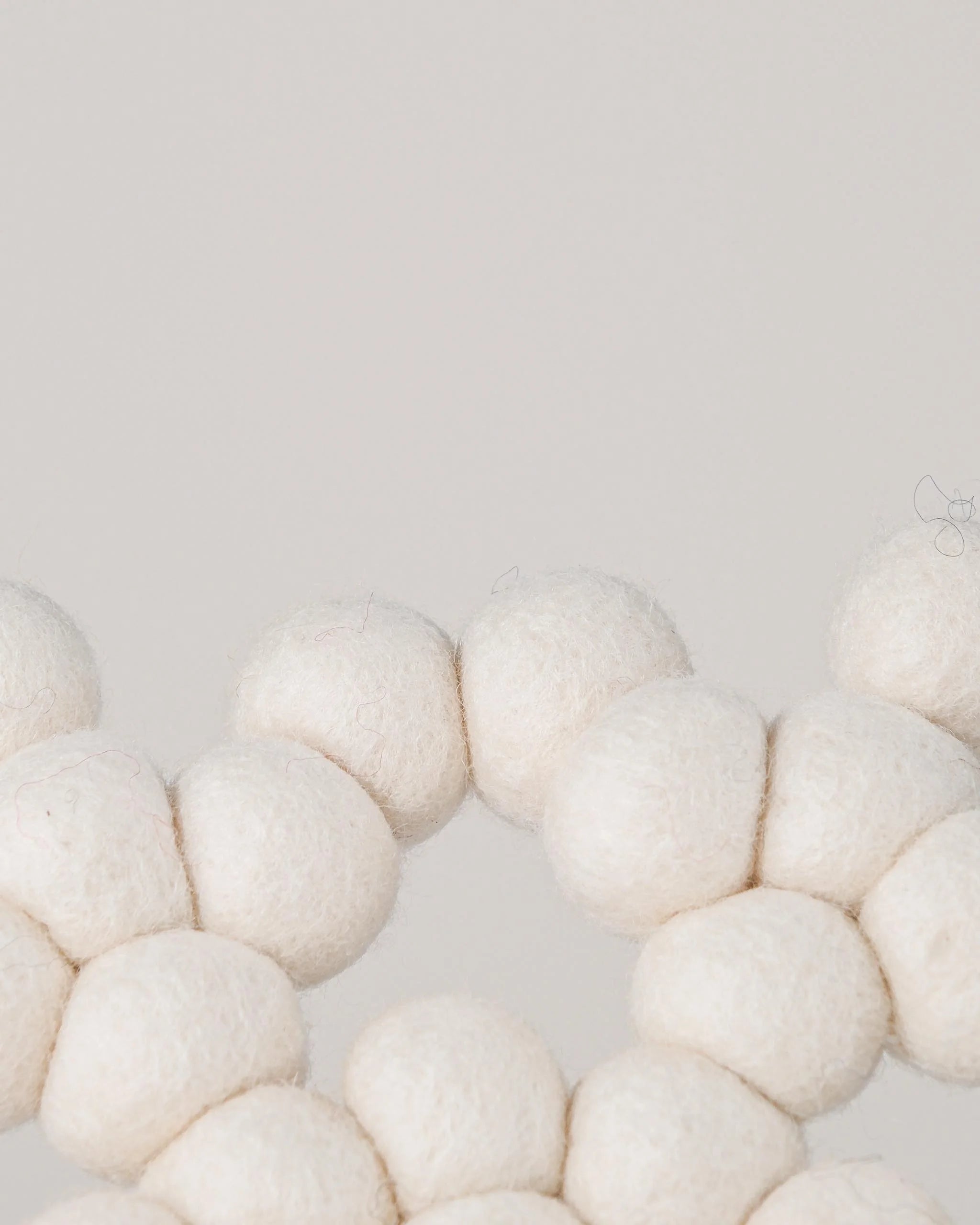 Dessous de plat boule en feutrine flocon sur un fond blanc détail zoom matière.