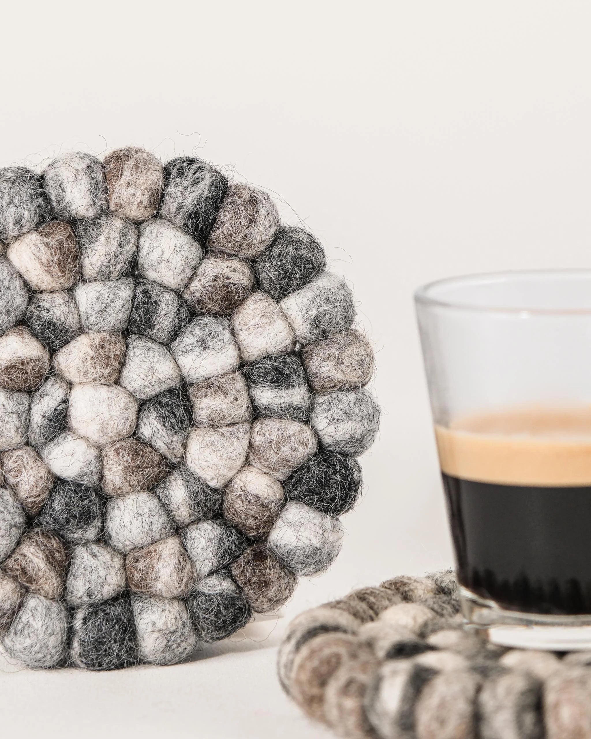 Set de 2 sous verre boule galet en feutrine sur un fond blanc détail zoom matière.