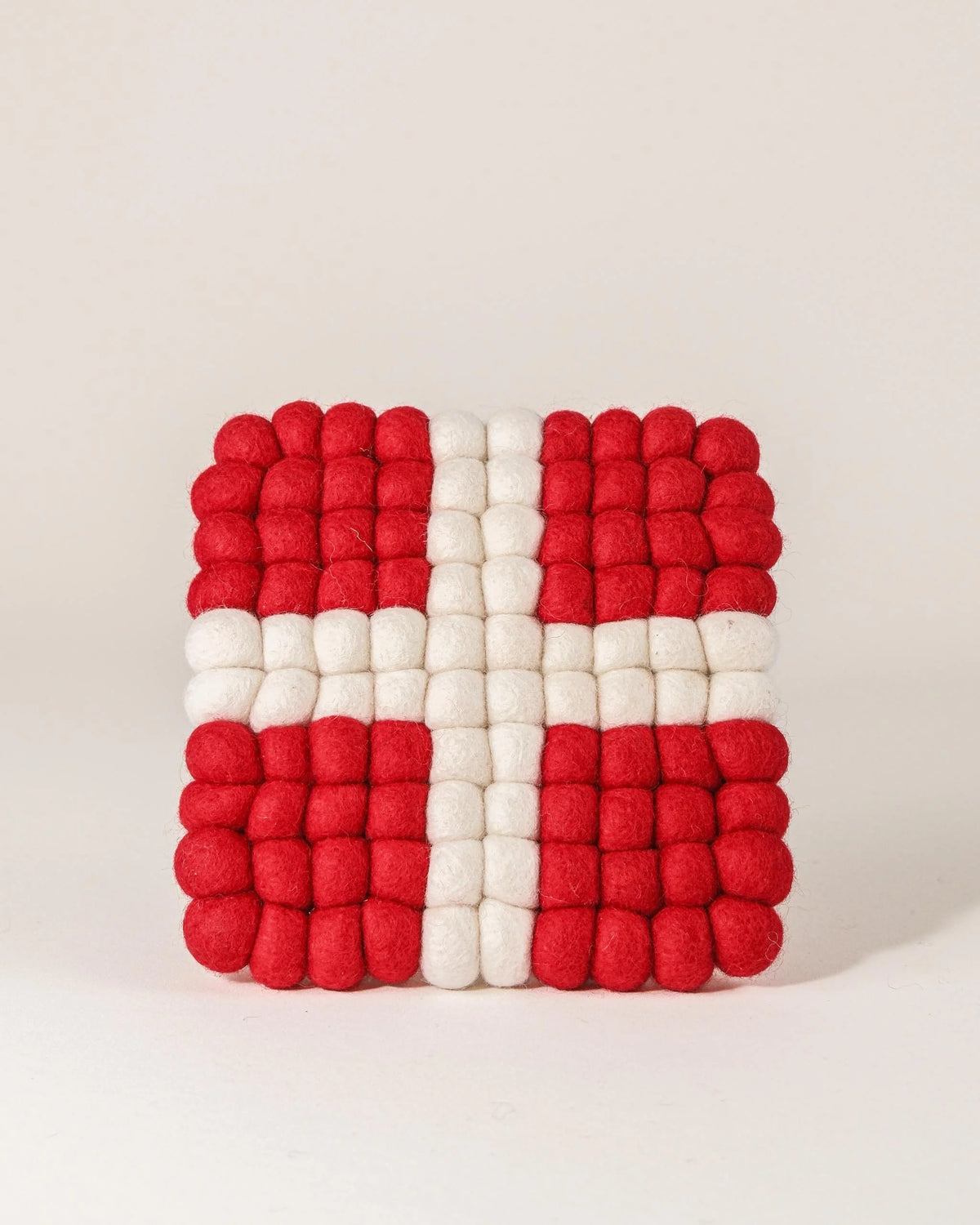 Dessous de plat boule en feutrine drapeau Savoie sur un fond blanc.