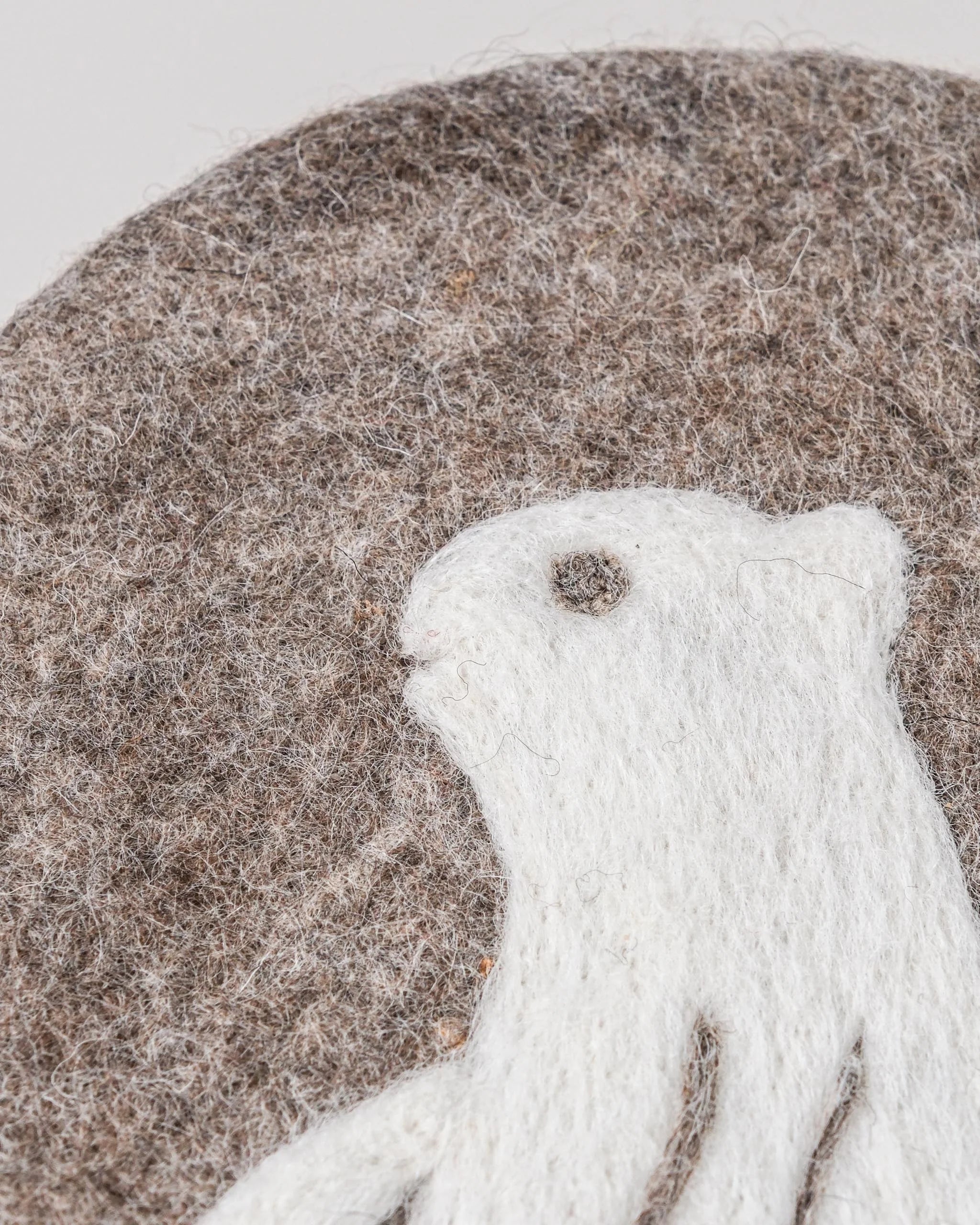 Dessous de plat boule en feutrine motif marmotte sur un fond blanc détail zoom matière.