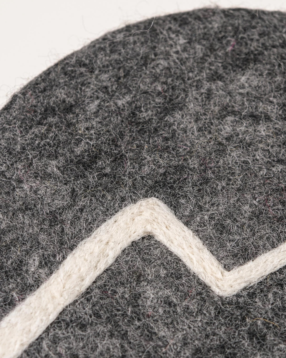 Dessous de plat boule en feutrine motif montagne sur un fond blanc détail zoom matière.