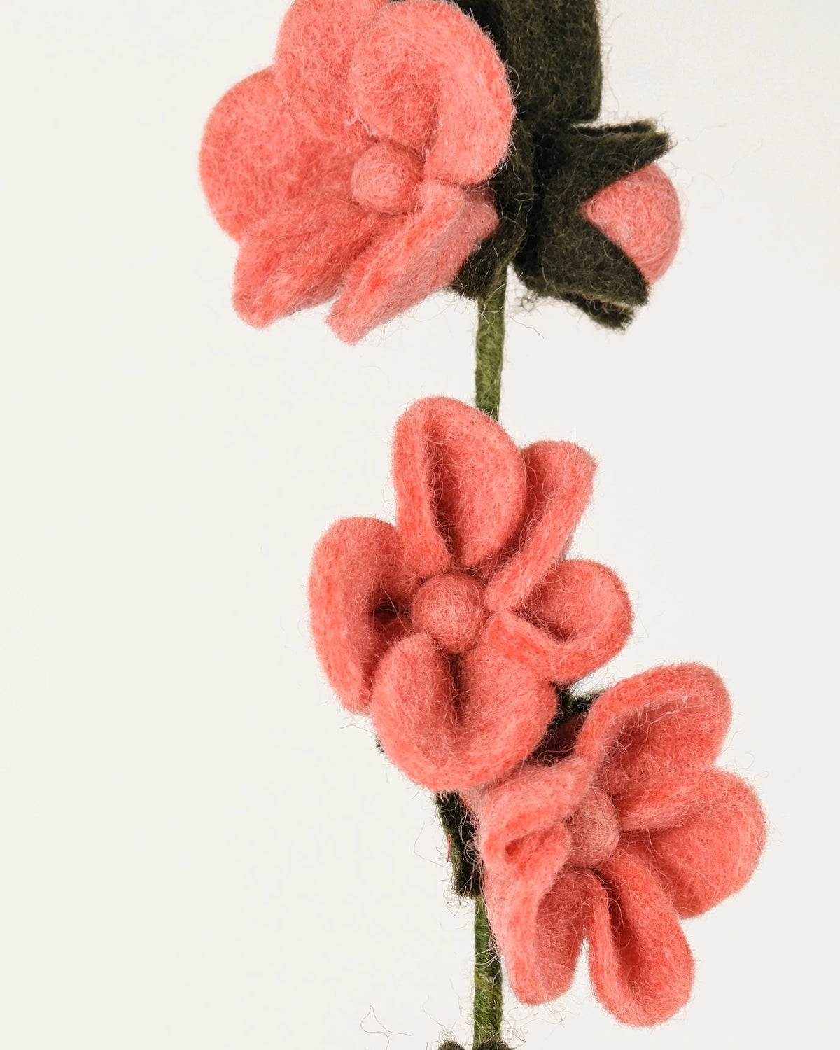 Fleur de pecher en feutrine sur un fond blanc détail zoom matière.
