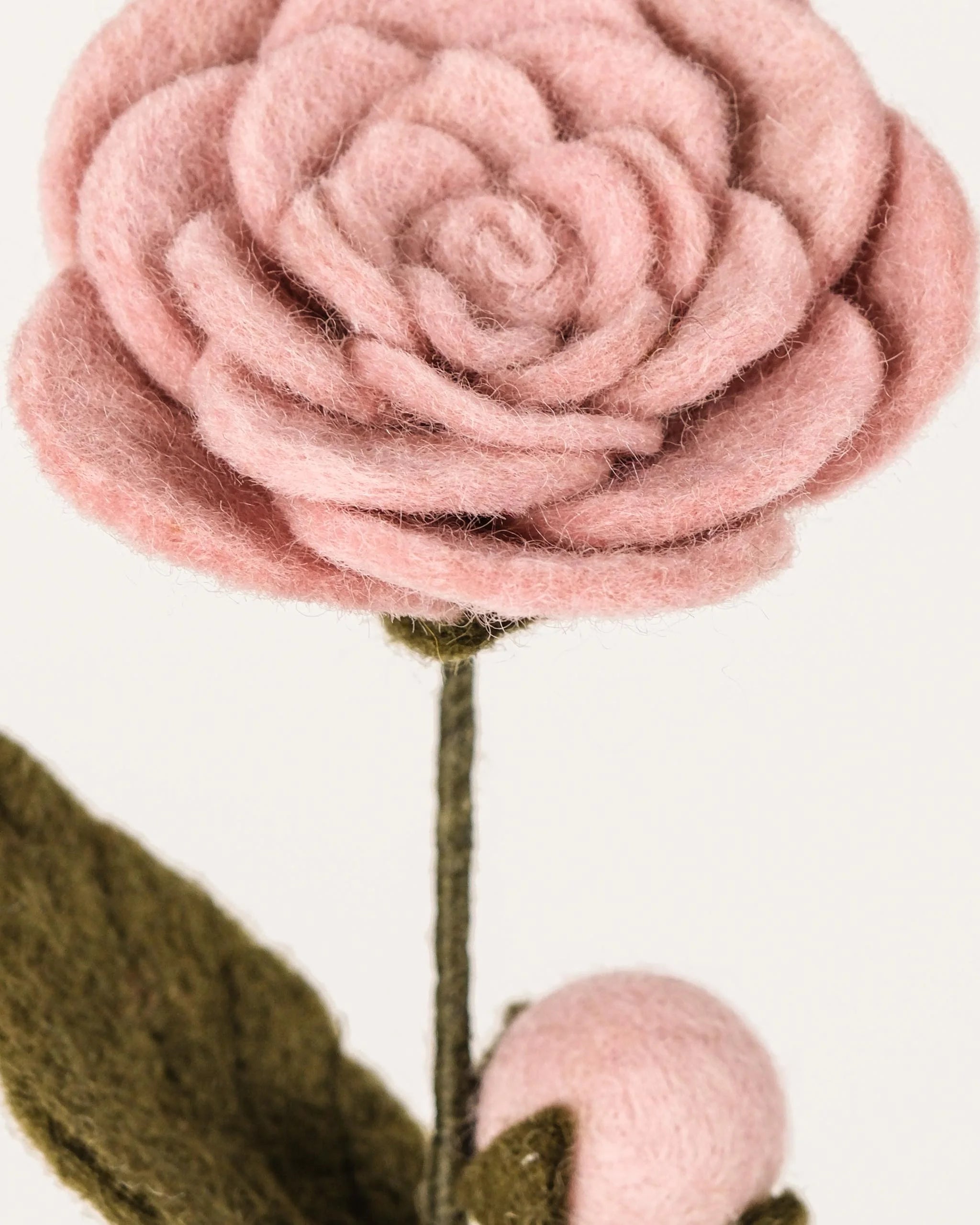 Camélia rose en feutrine sur un fond blanc détail zoom matière.