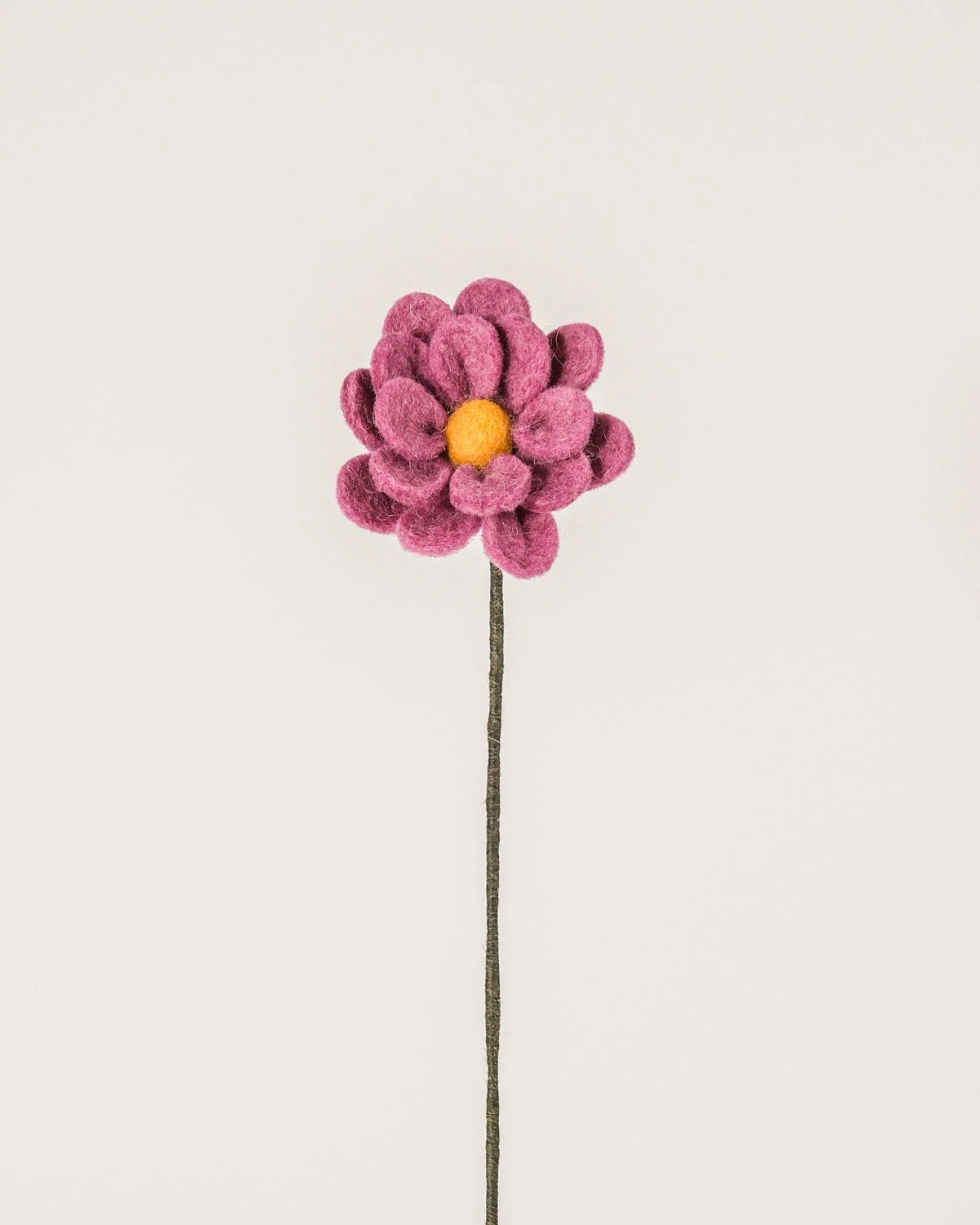 Photo d'une anémone violet clair en feutrine sur un fond blanc.