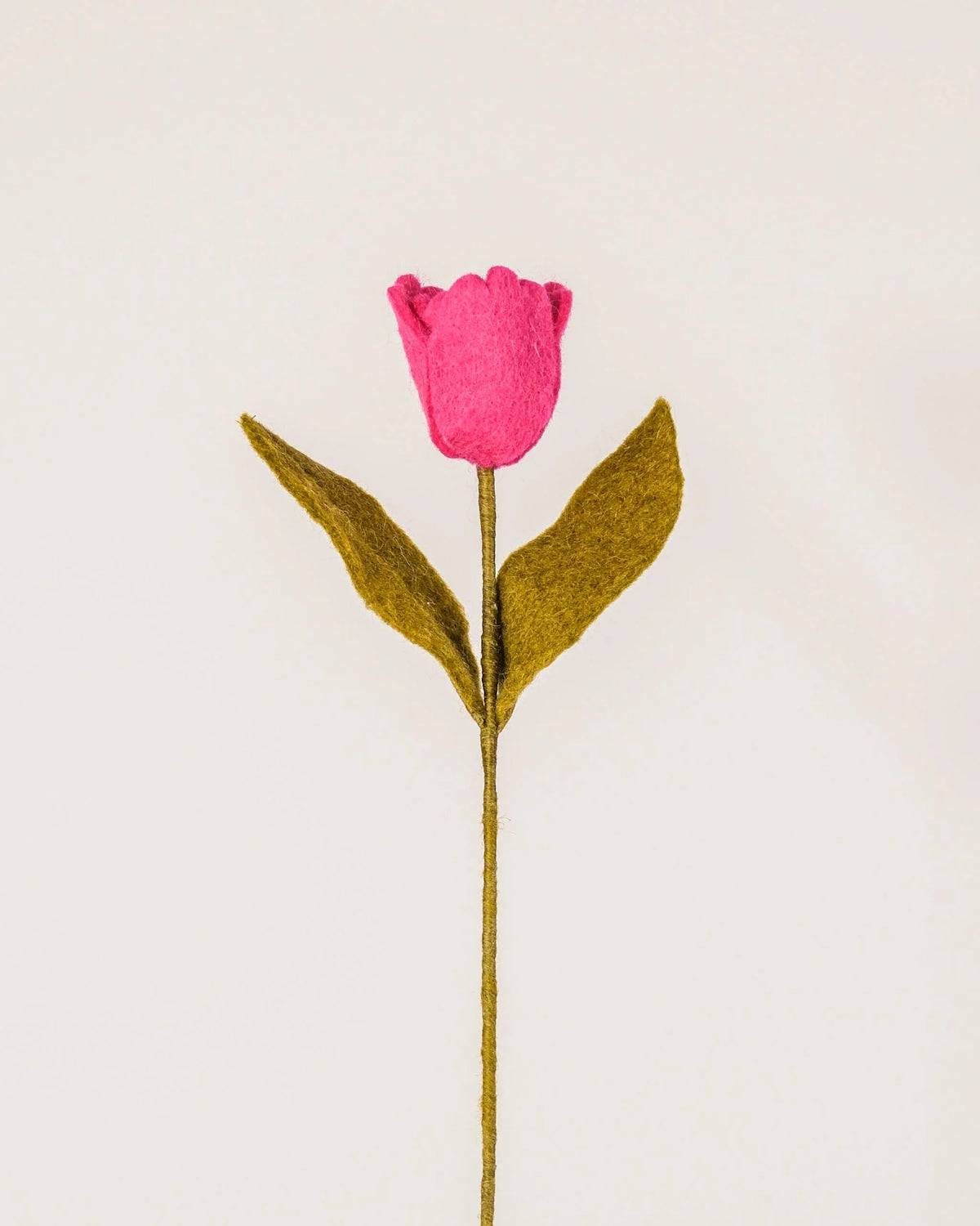 Photo d'une tulipe rose en feutrine sur un fond blanc style photo packshot.