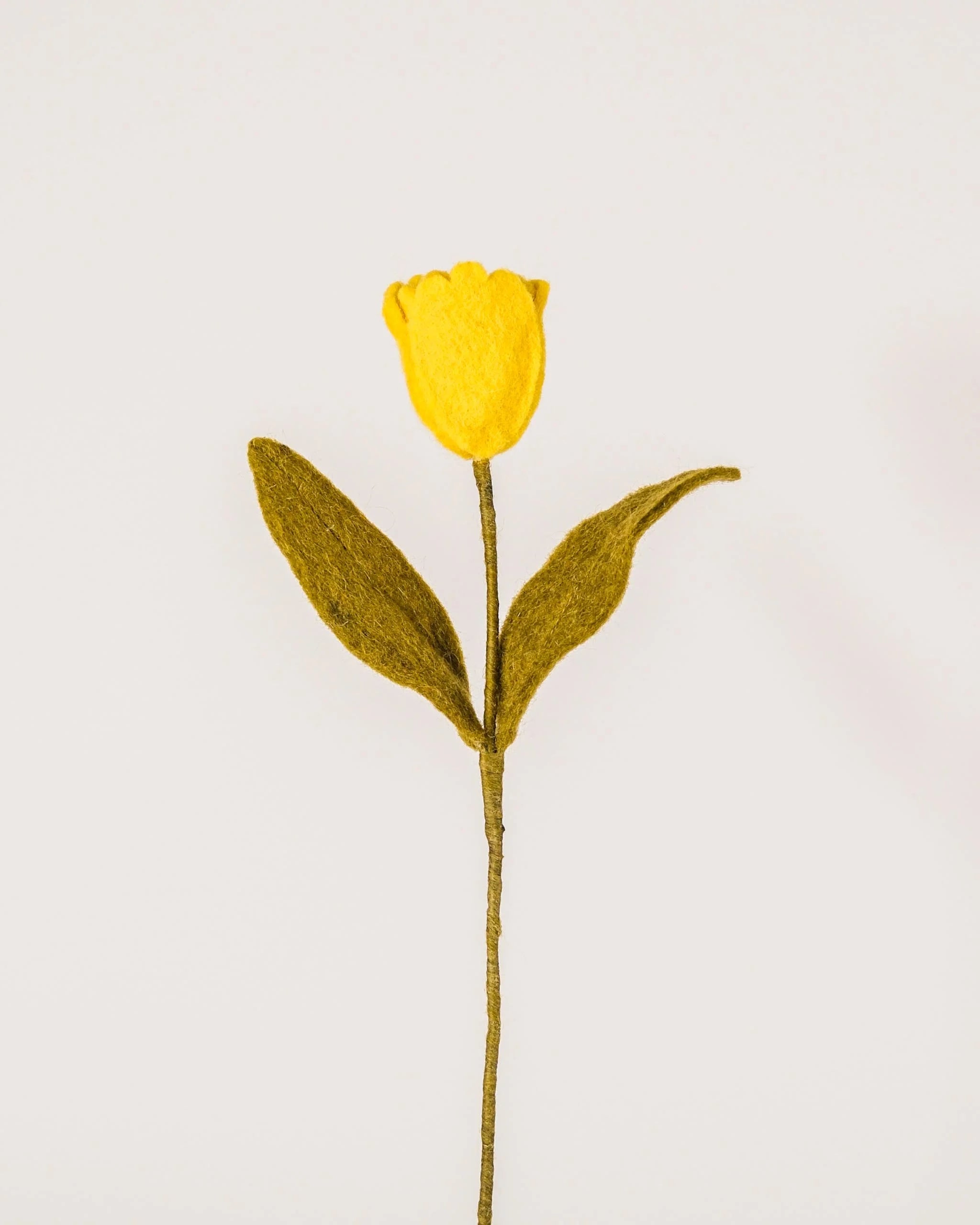 Photo d'une tulipe jaune en feutrine sur un fond blanc style photo packshot.