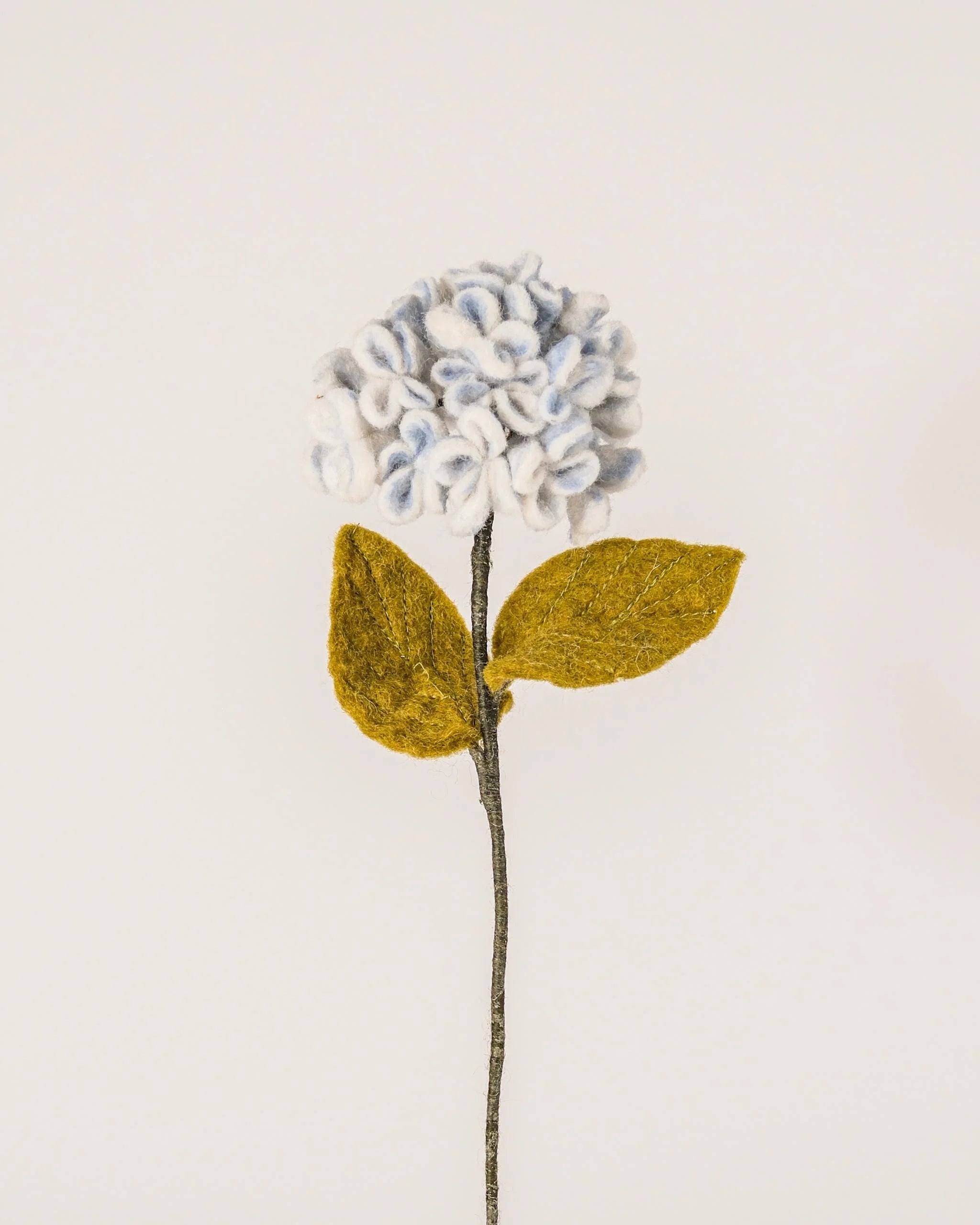 Photo d'une hortensia bleu en feutrine sur un fond blanc.