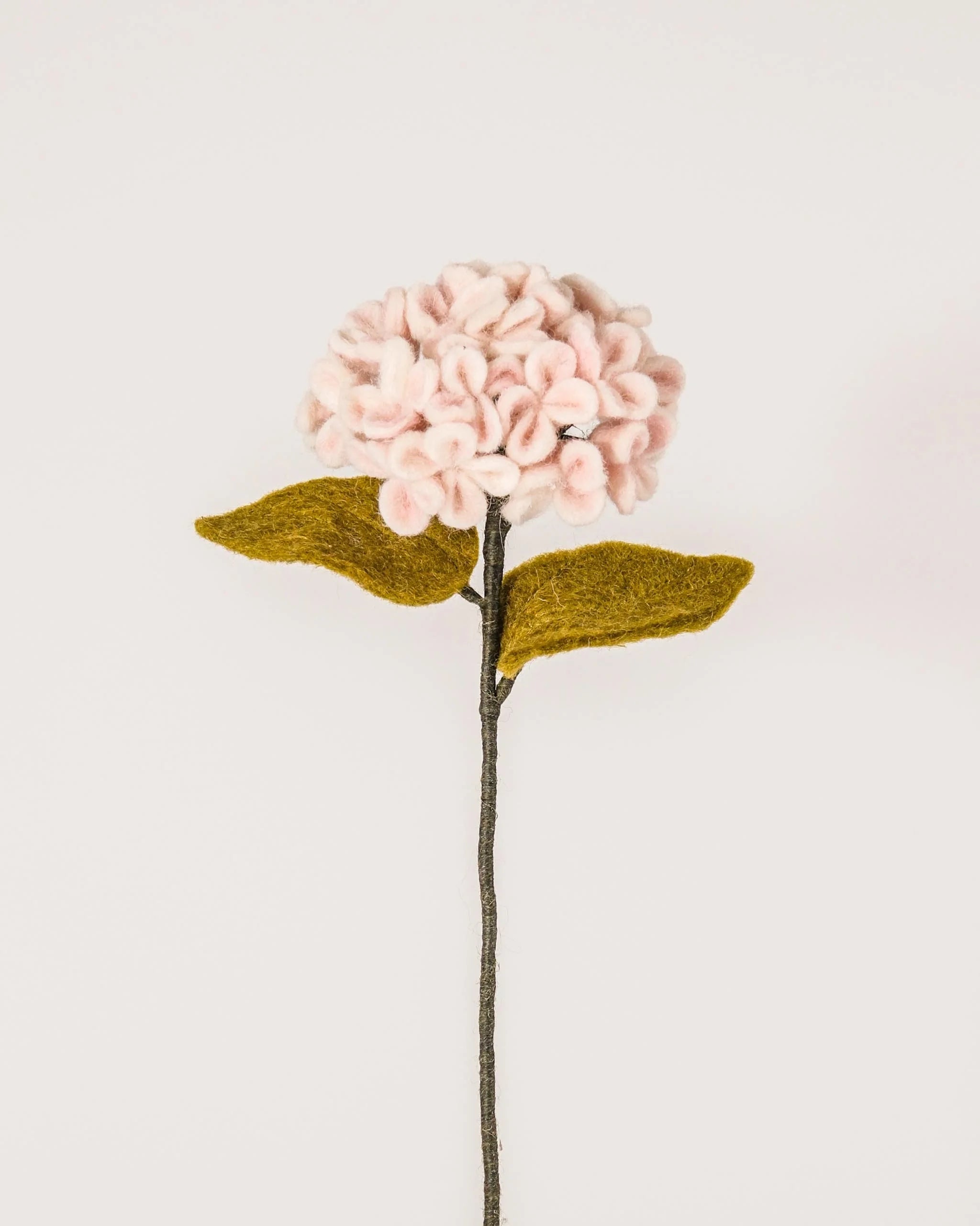 Photo d'une hortensia rose en feutrine sur un fond blanc.