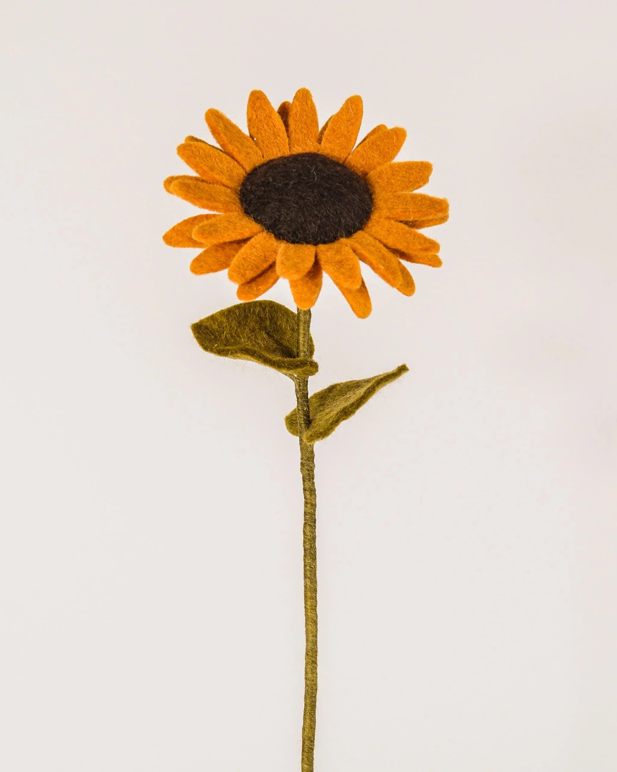 Photo d'un tournesol en feutrine sur un fond blanc style photo packshot.