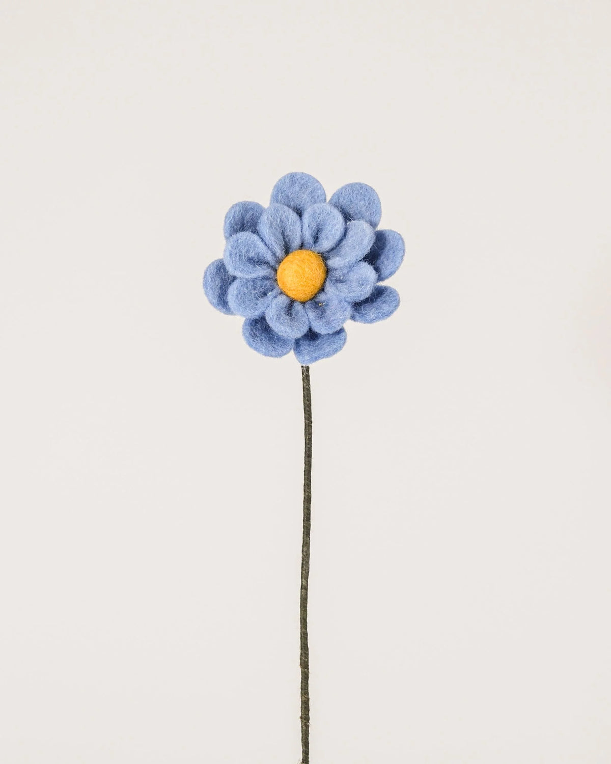 Photo d'une anémone bleu en feutrine sur un fond blanc.