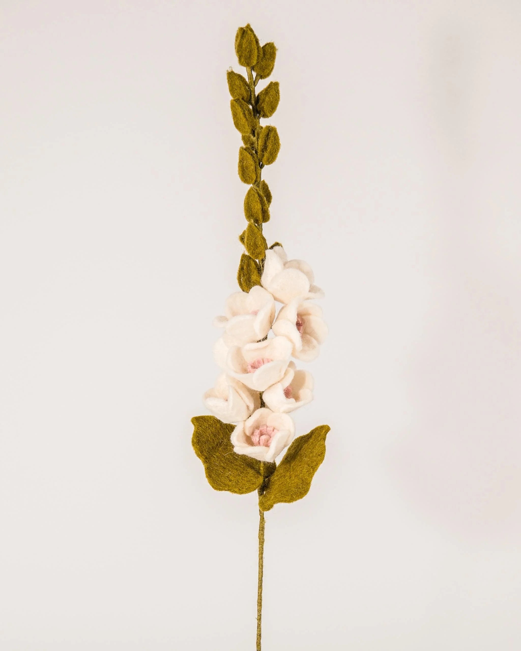 Photo d'une rose trémière en feutrine sur un fond blanc style photo packshot.