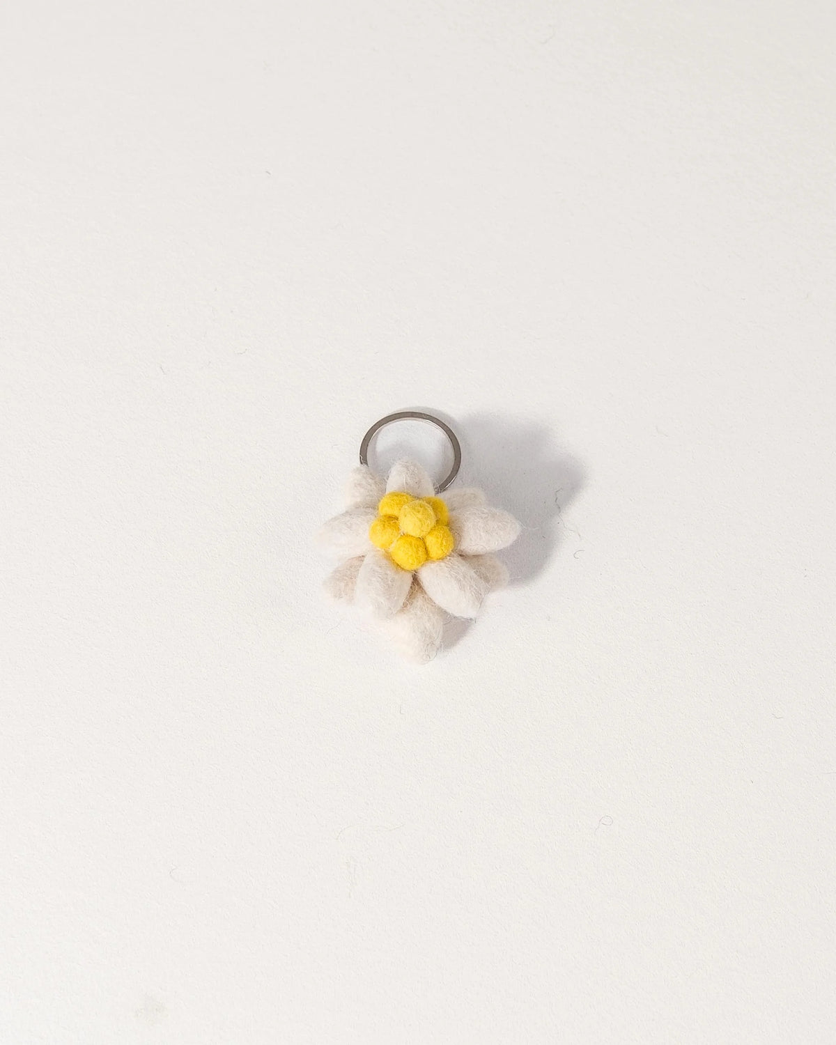 Porte clé edelweiss en feutrine sur un fond blanc.