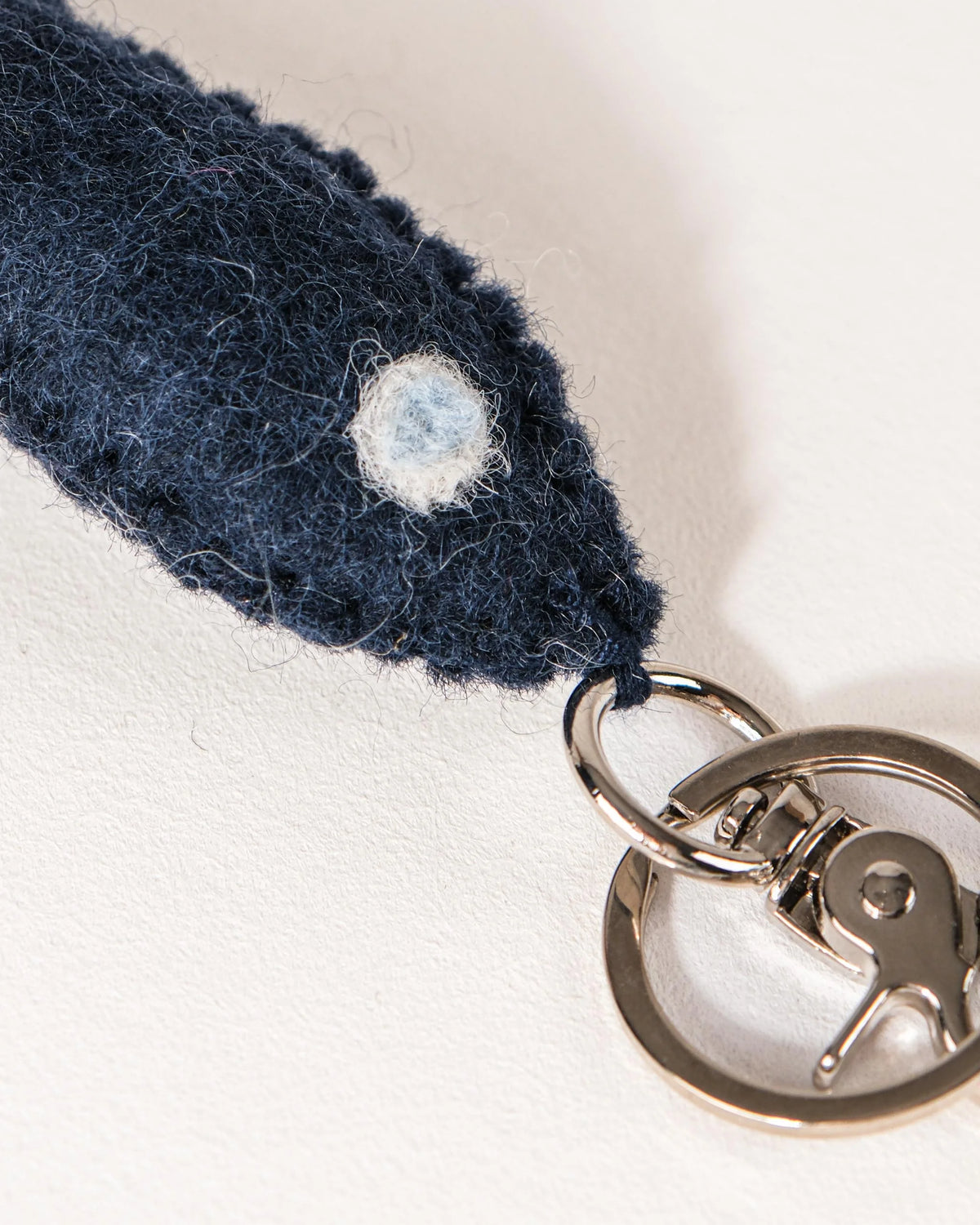 Porte clé petit poisson bleu en feutrine sur un fond blanc détail zoom matière.