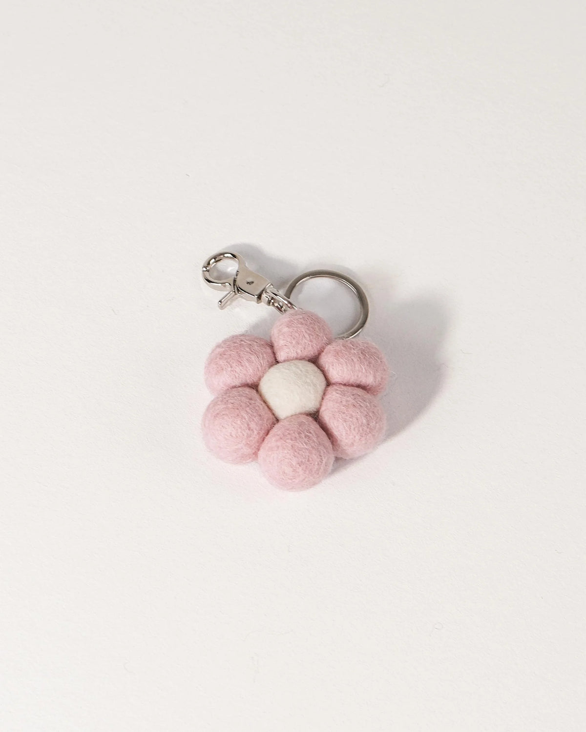 Porte clé fleur rose en feutrine sur un fond blanc.
