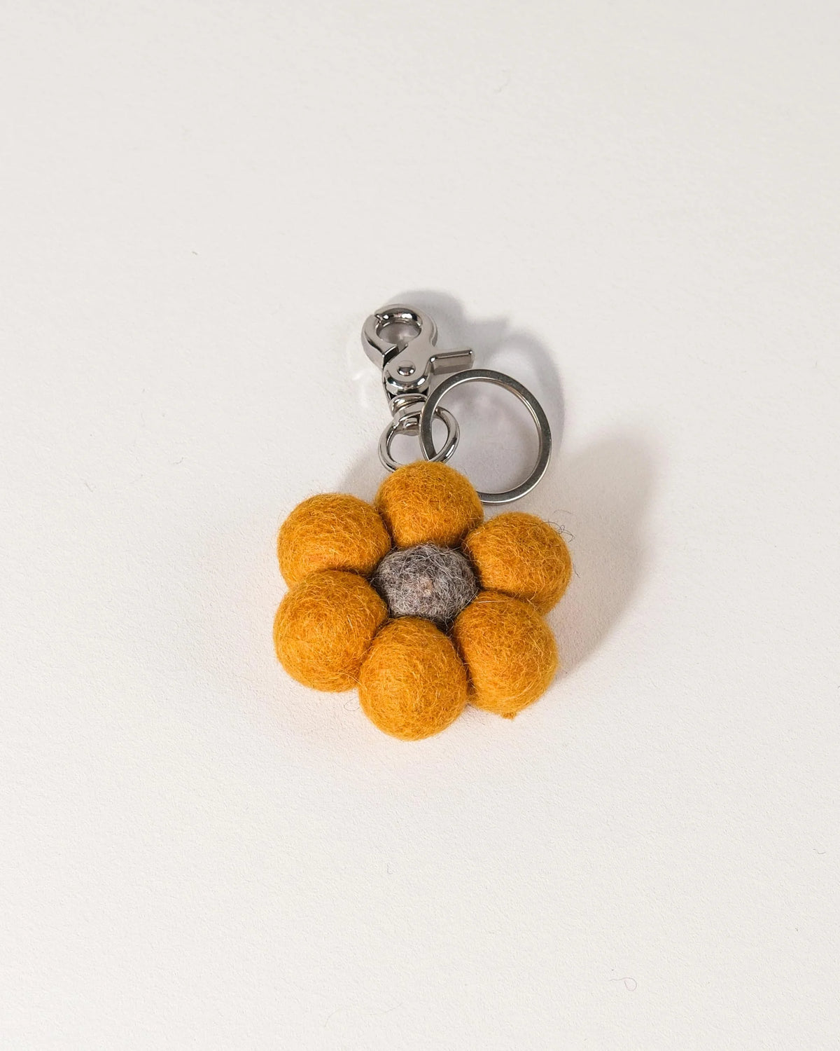 Porte clé tournesol en feutrine sur un fond blanc.