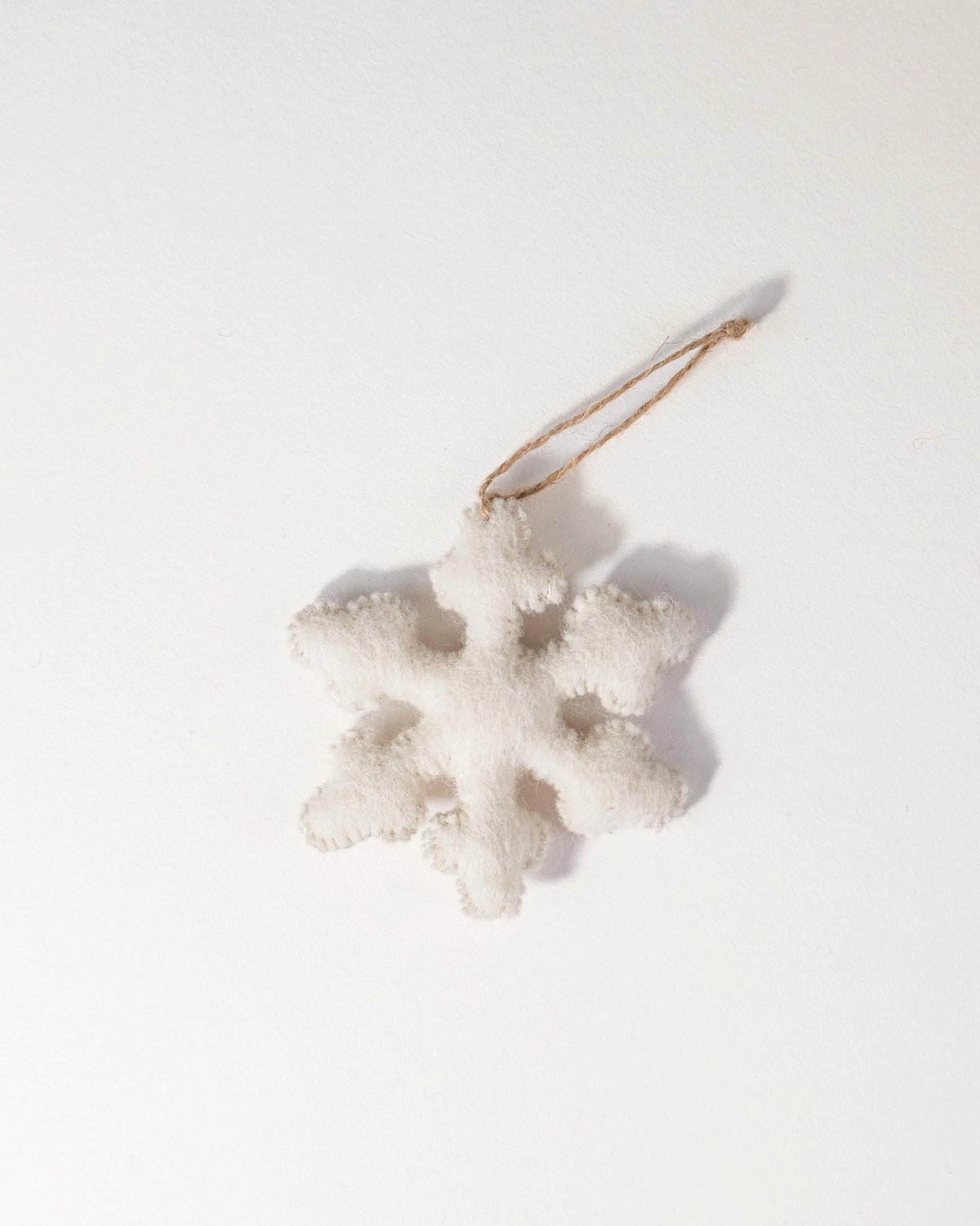 Flocon blanc en feutrine a suspendre sur un mure blanc.