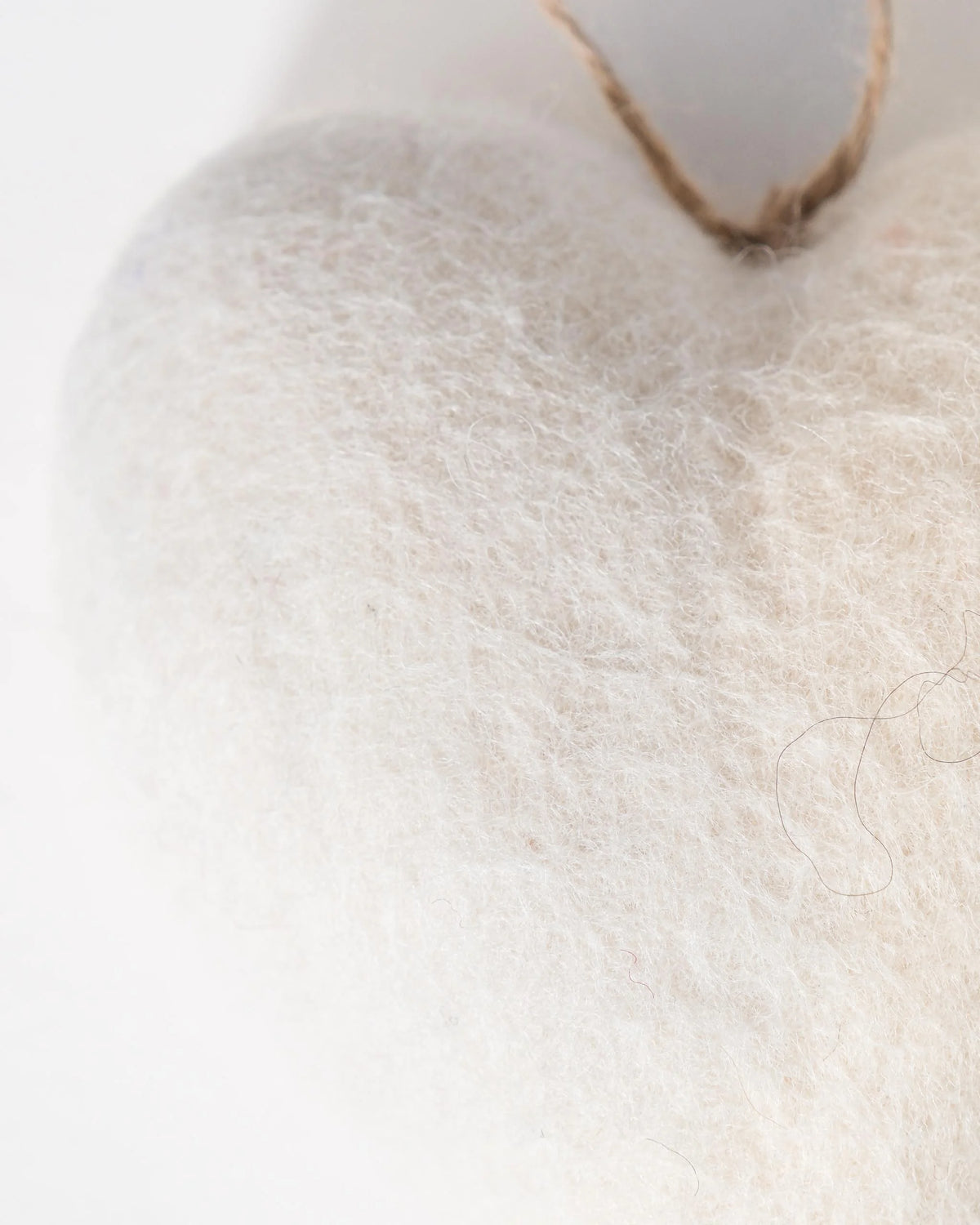 Coeur blanc a suspendre sur fond blanc détail zoom matière.