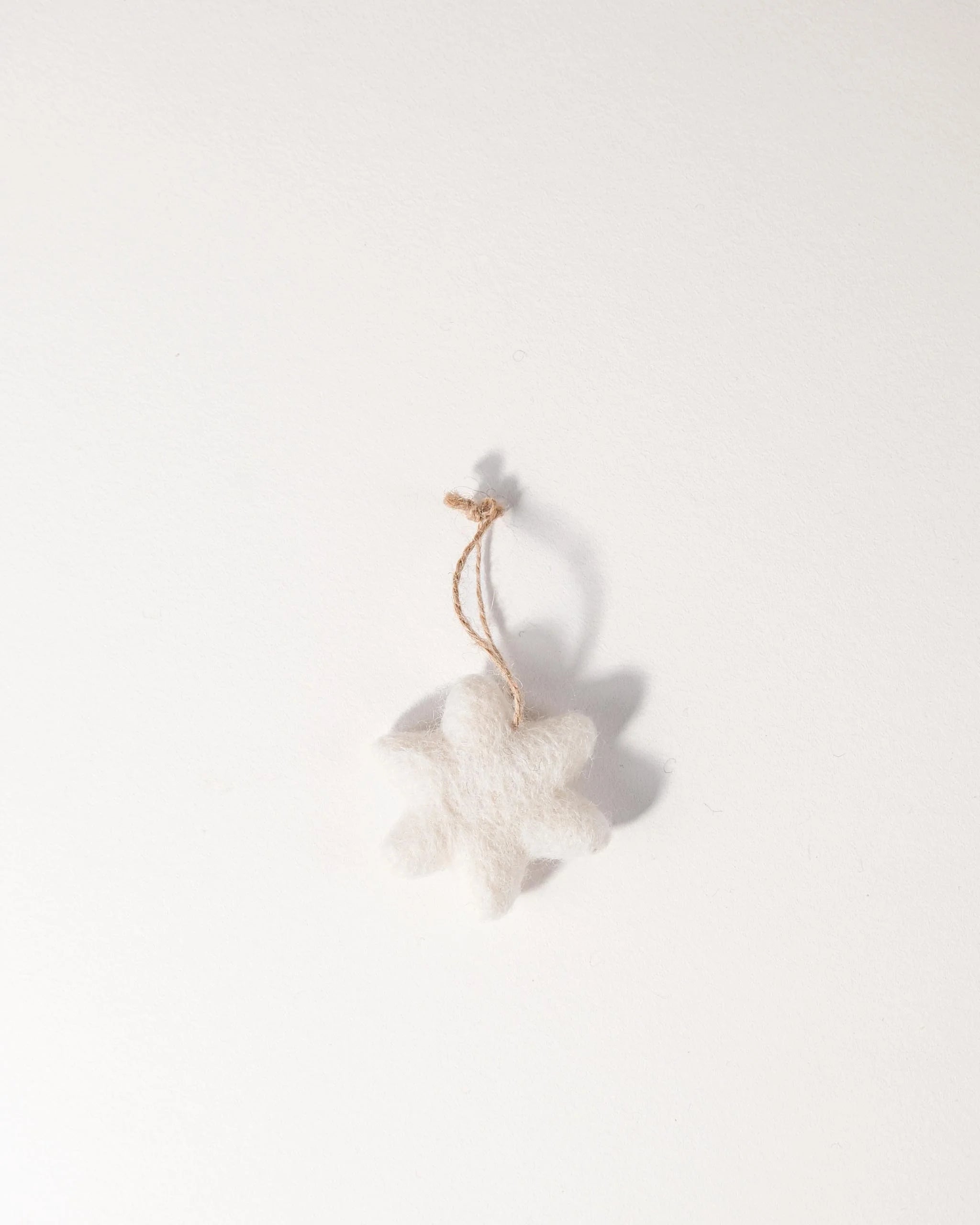 Mini étoile à suspendre en feutrine sur un fond blanc.