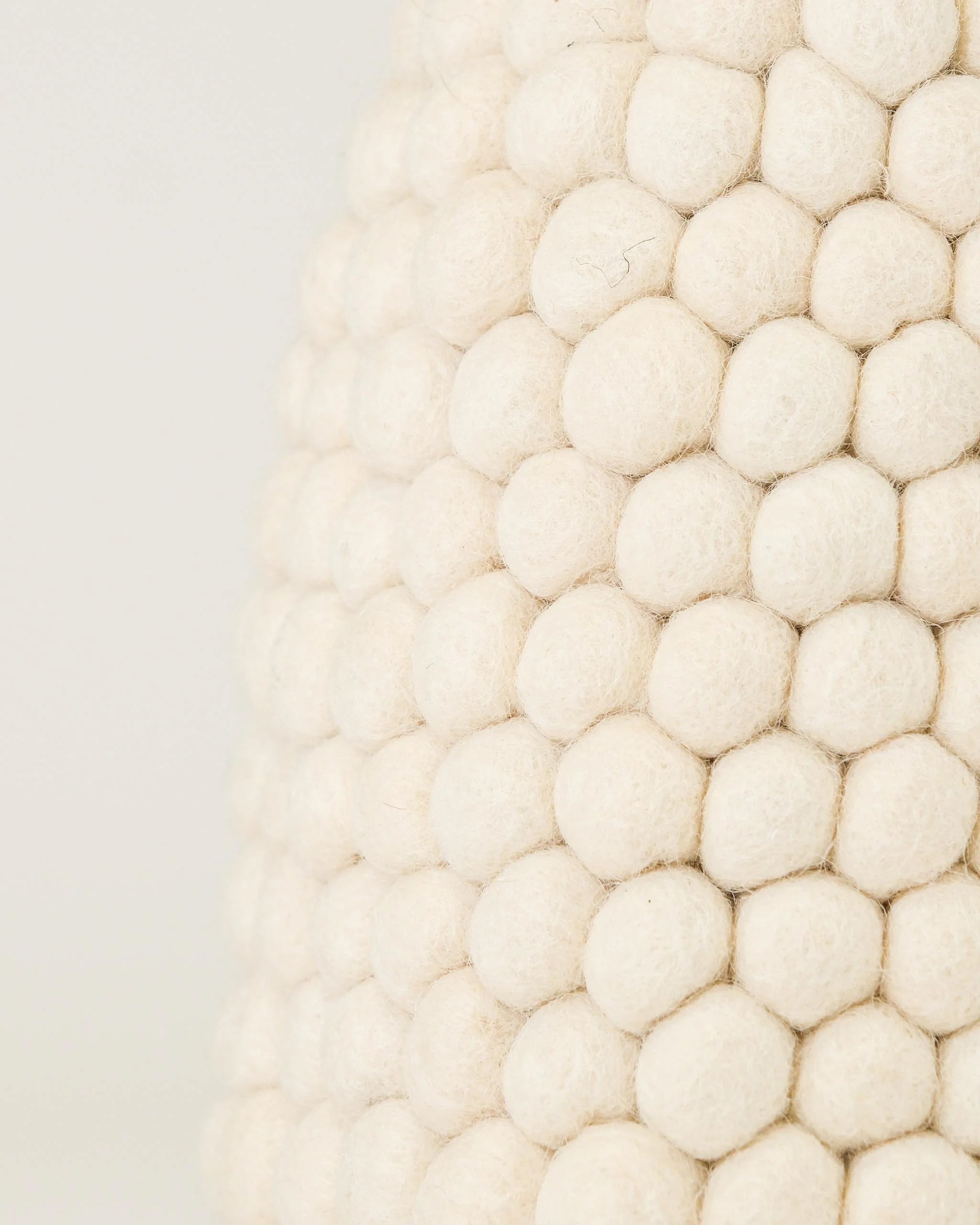 Zoom sur un vase en feutrine blanc.