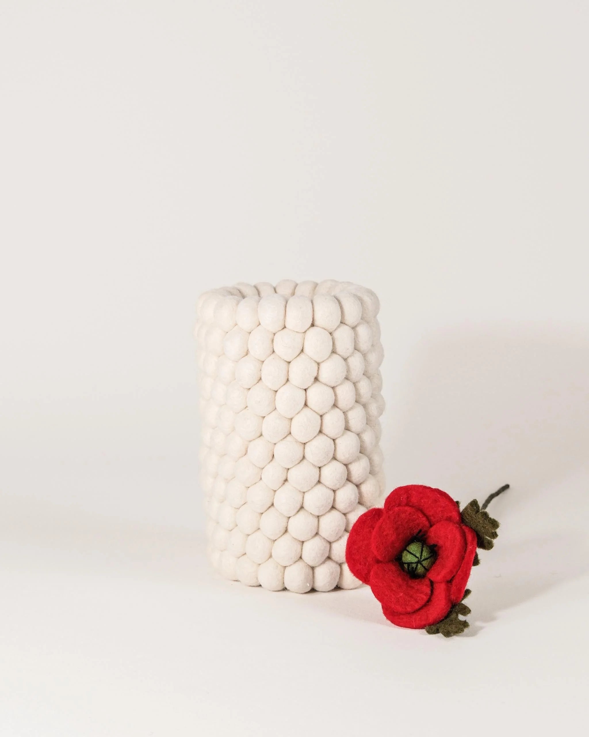 Vase double usage en feutrine blanc sur un fond blanc.