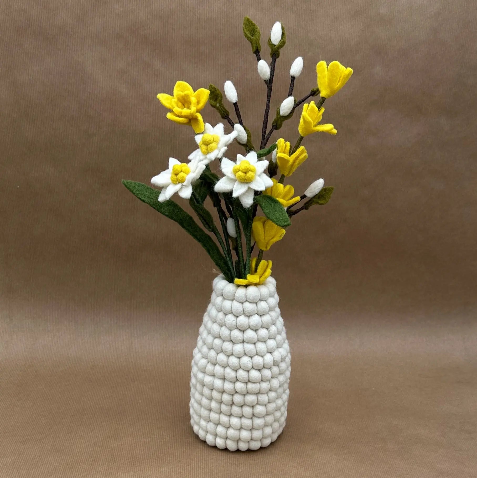 Bouquet "Éclat d'Alpage" composé d'edelweiss et jonquilles en laine dans un vase alvéolé blanc New Heidi.