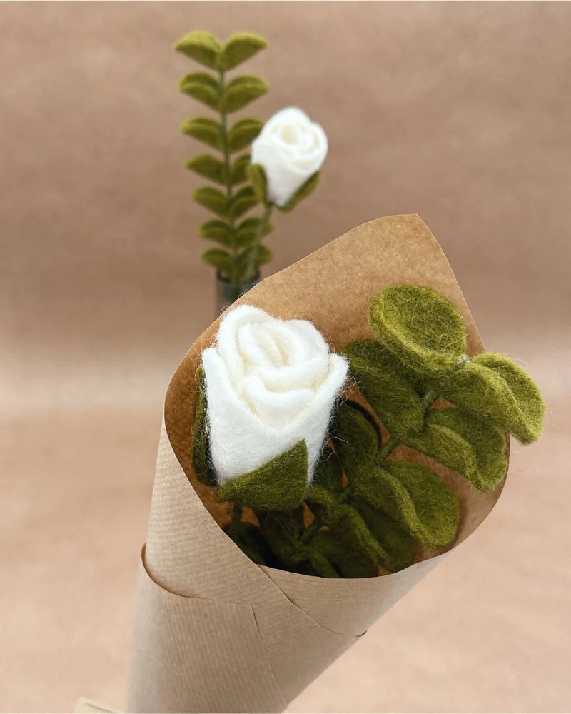 Détail d'un bouquet de rose blanche et eucalyptus artisanaux New Heidi emballé dans du papier kraft recyclé.