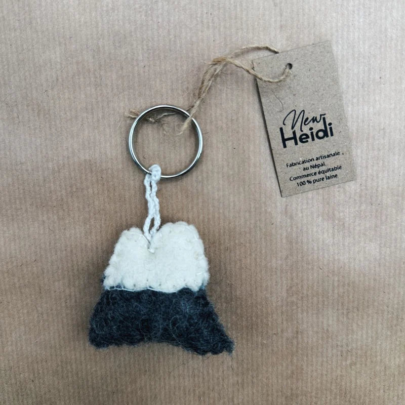 Porte-clé artisanal montagne New Heidi en feutrine grise et blanche avec son étiquette.