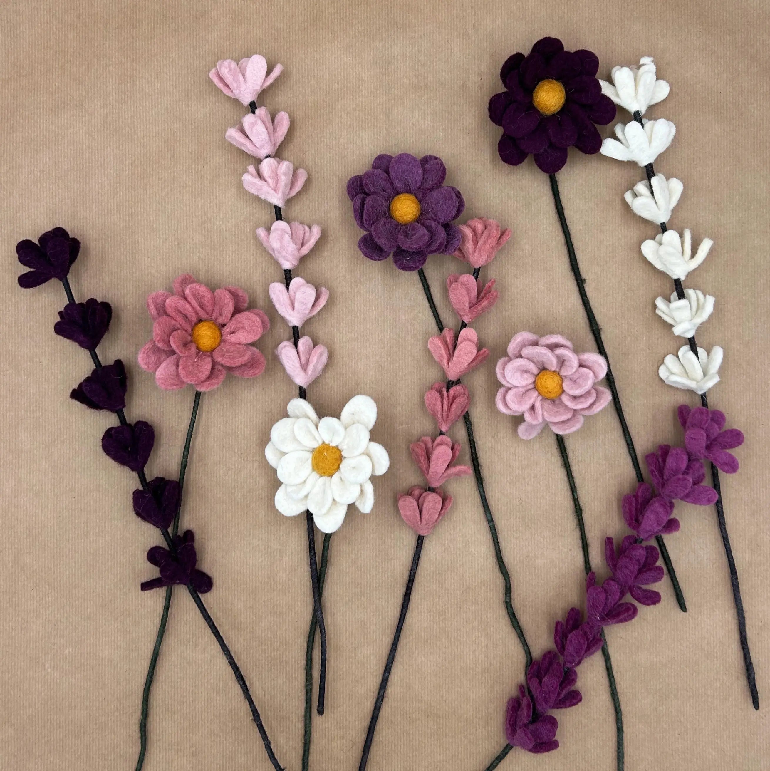 Présentation à plat des 10 tiges d'anémones et genêts en feutrine dans les tons blanc, rose et violet.