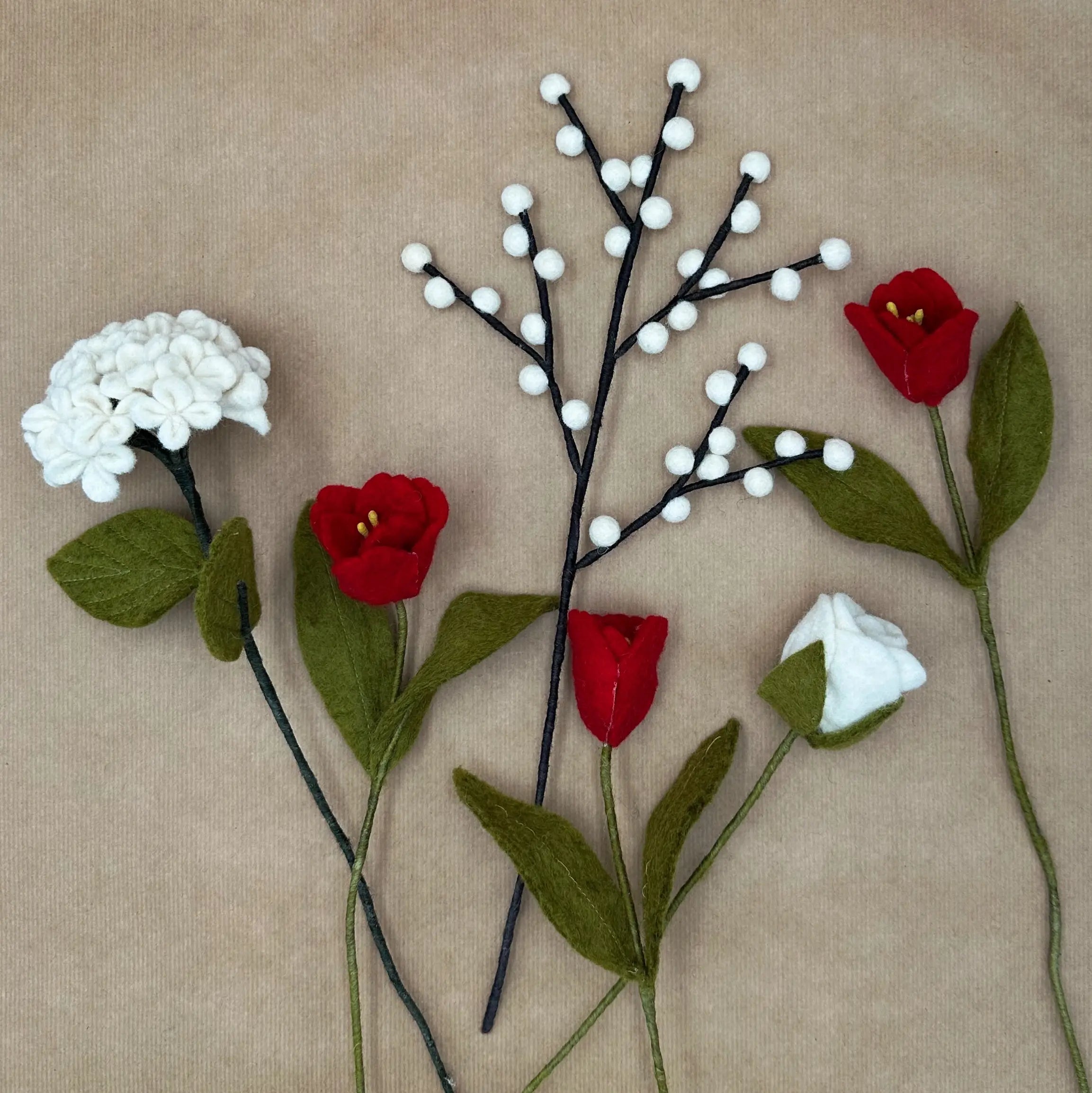Présentation des tiges artisanales (tulipes, hortensia, rose, baies) du bouquet Passion Givrée.
