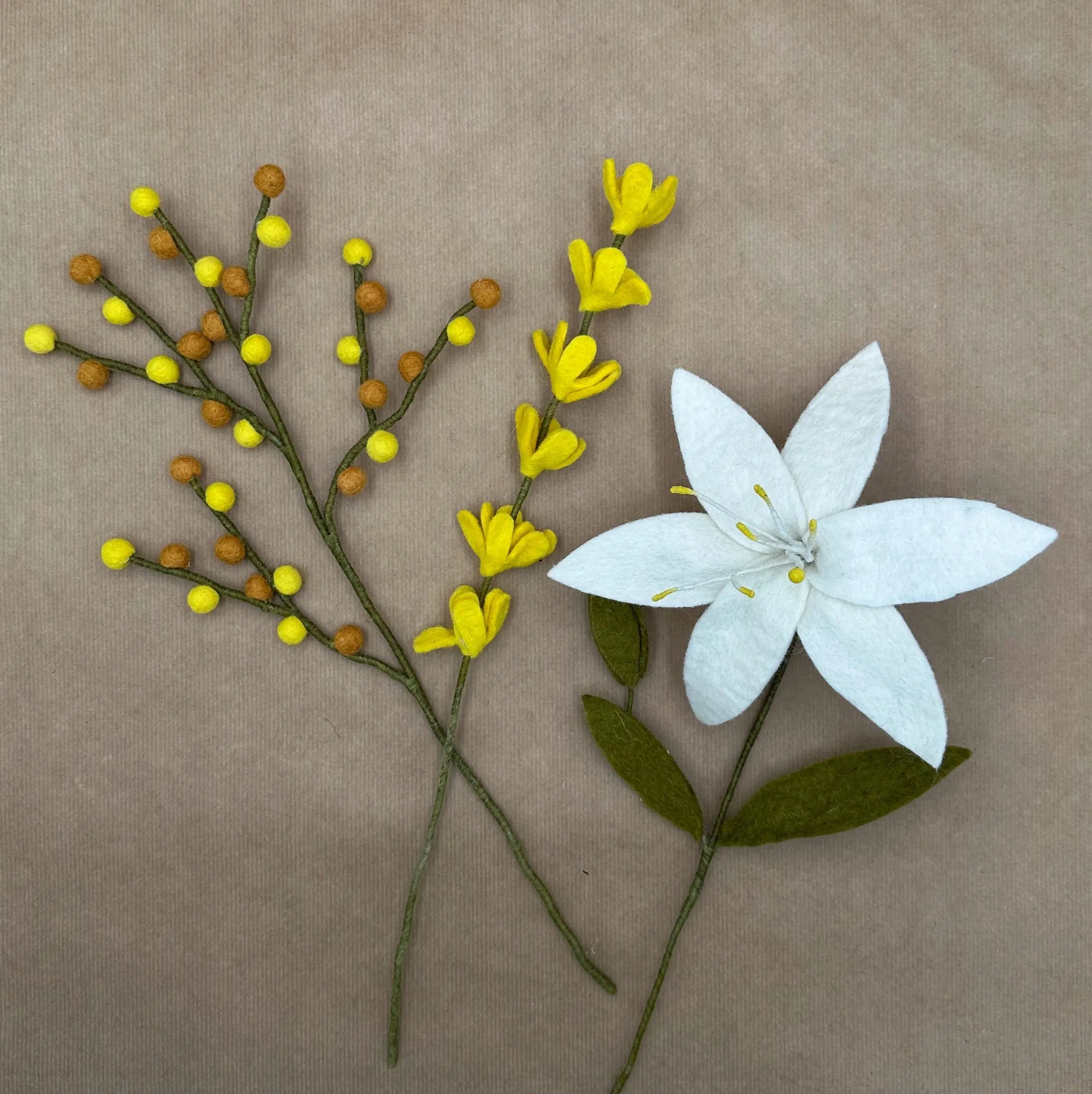 Présentation des trois tiges artisanales (lys, genêt et baies) du bouquet Lumière de Lys New Heidi.