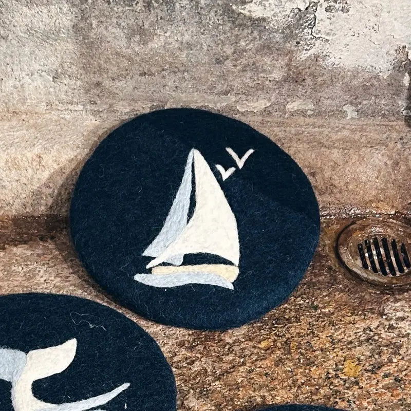 Dessous de plat rond en feutrine bleu avec motif voilier blanc artisanal New Heidi.