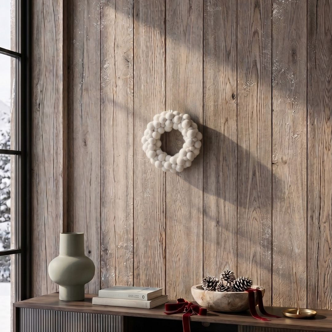 Couronne de boules blanches en feutrine New Heidi suspendue sur un mur.