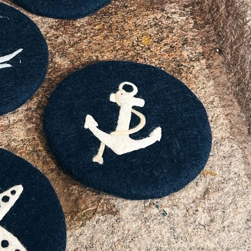 Gros plan sur le motif ancre finement travaillé à la main sur le dessous de plat en laine New Heidi.