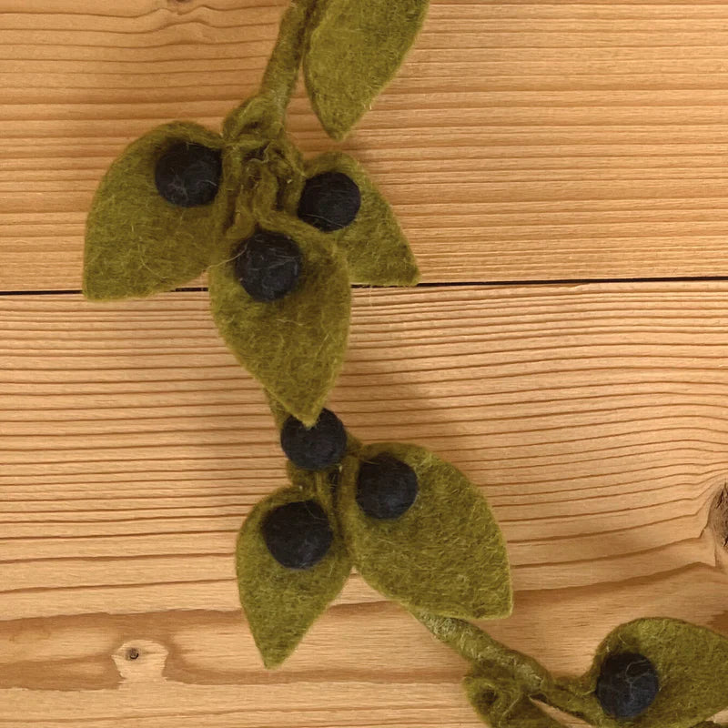 Détail des baies de myrtilles bleues et feuilles vertes faites main en feutrine de laine.