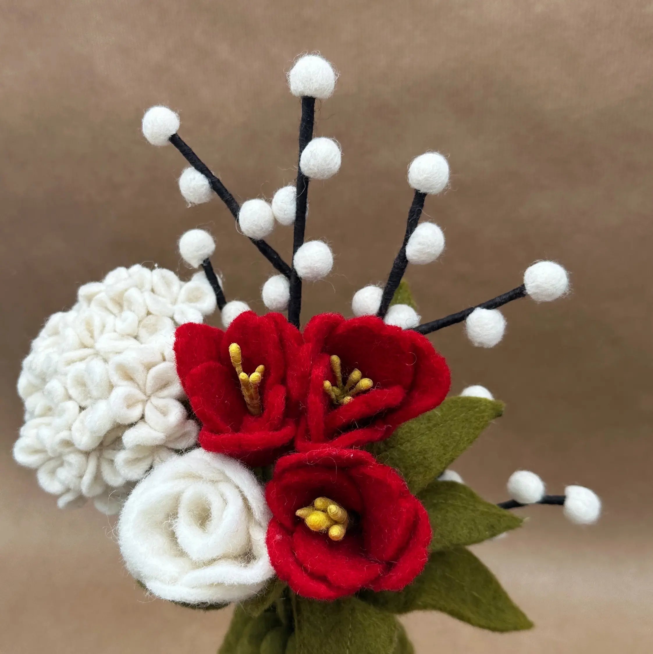 Gros plan sur les détails artisanaux des tulipes rouges et de l'hortensia blanc en laine New Heidi.