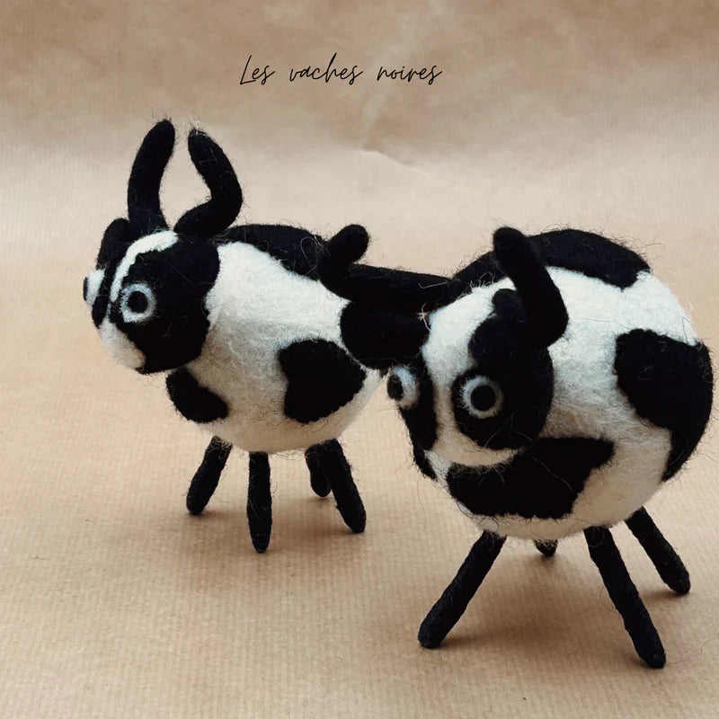 Mise en scène de deux vaches boules noires New Heidi faites à la main au Népal en laine bouillie.