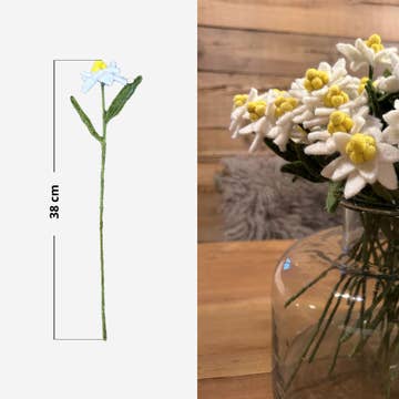 Détail d'une tige d'edelweiss en feutrine de 38 cm de haut à côté d'un bouquet décoratif.