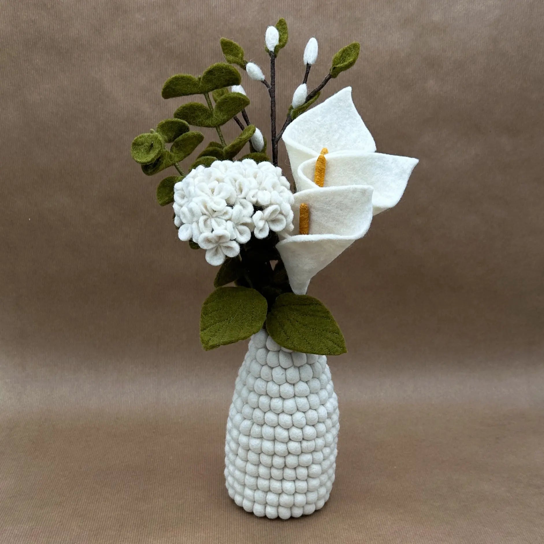 Bouquet Pureté de l'Arum New Heidi présenté dans notre vase en feutrine blanc alvéolé.