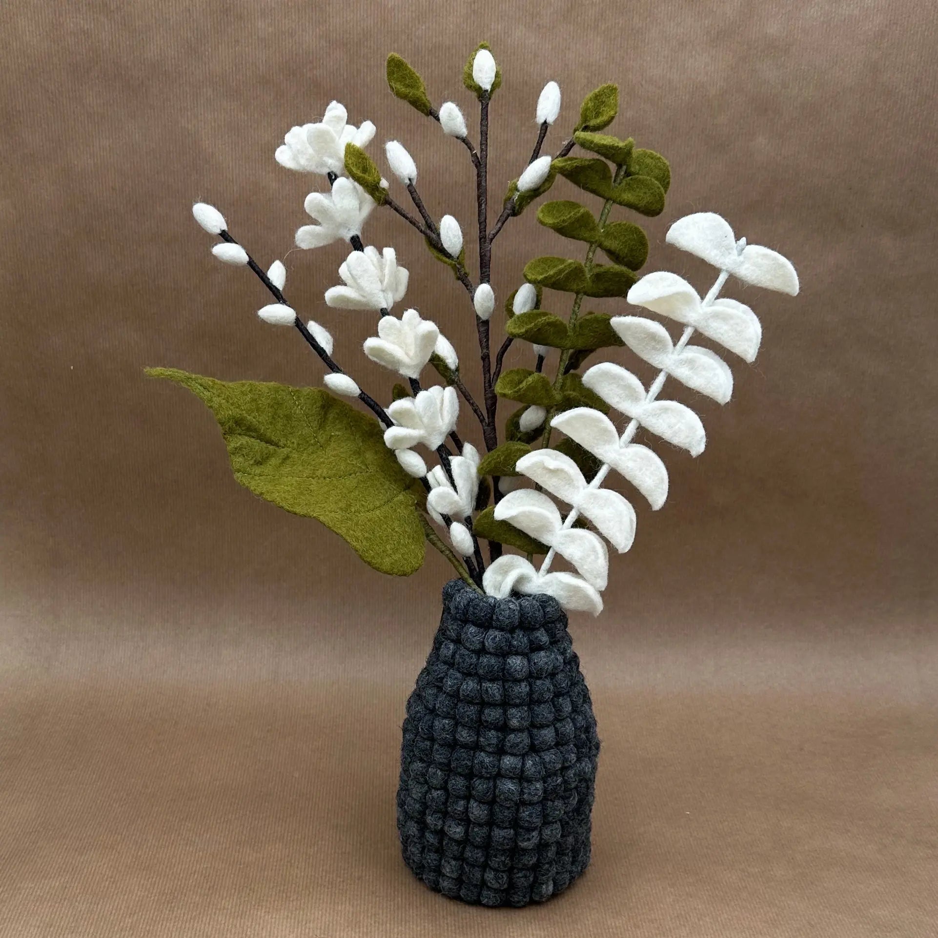 Détail du bouquet Brume de Forêt présenté dans notre vase en feutrine gris anthracite alvéolé.