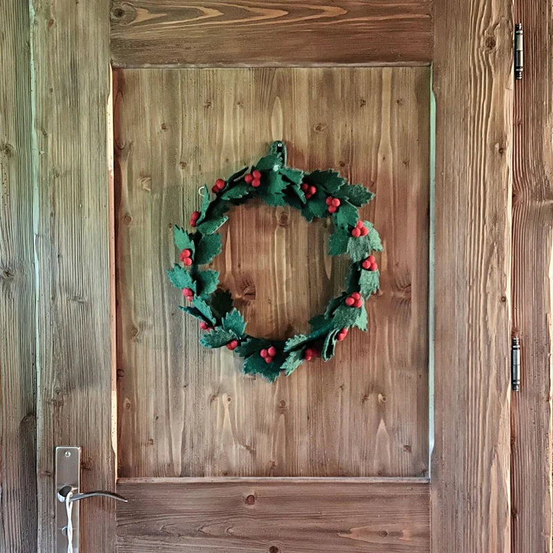 Grande couronne de houx New Heidi de 35 cm installée sur une porte pour une décoration de Noël majestueuse.
