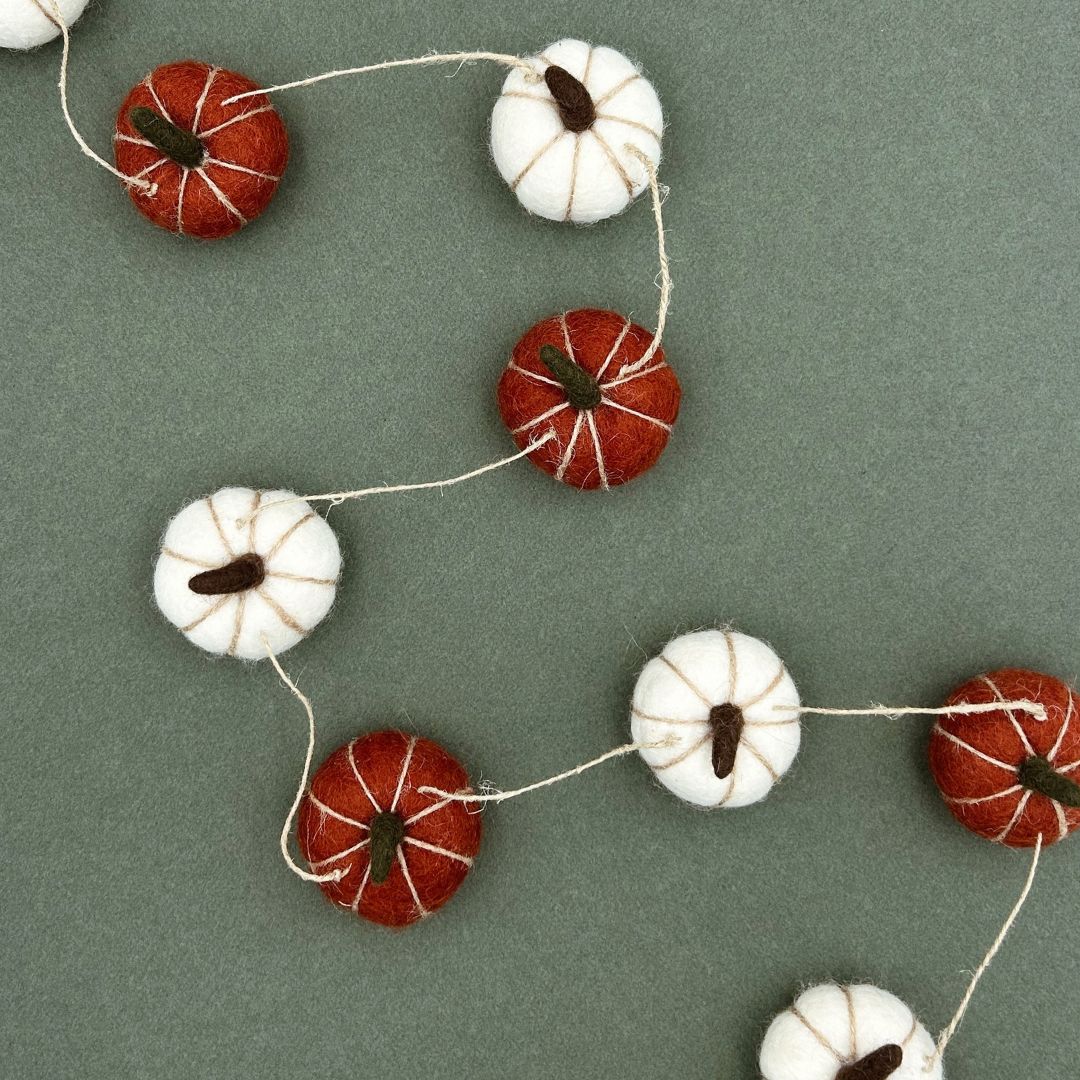 Guirlande d'automne New Heidi de 150cm composée de petites citrouilles artisanales en feutrine orange et blanche.