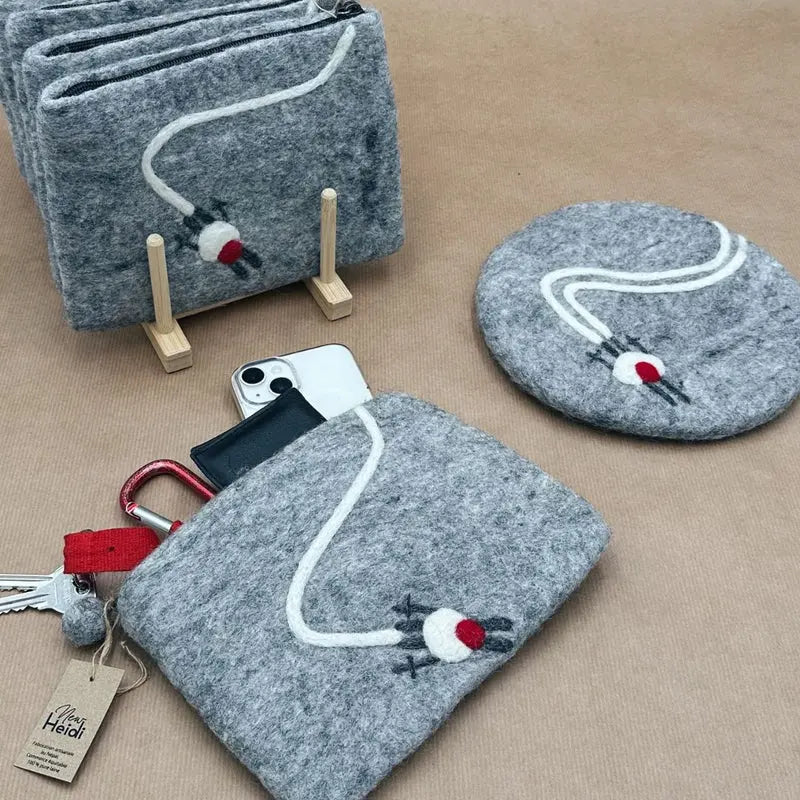 Présentation de la collection de pochettes en laine feutrée motif ski, fabrication éthique au Népal.
