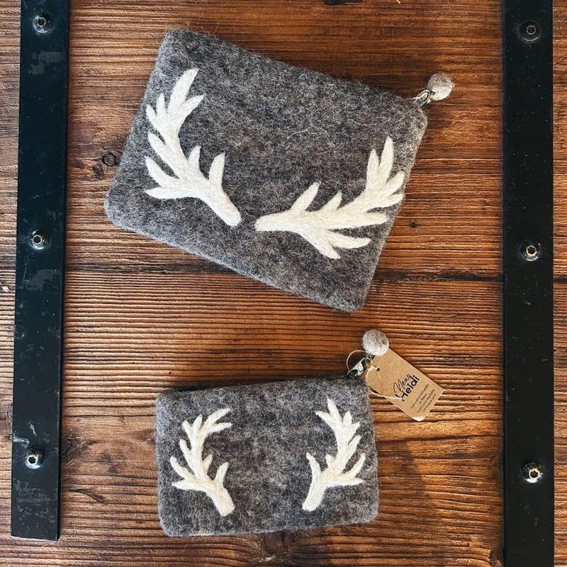 Pochettes de rangement marron motif cerf posées sur un support en bois rustique, style chalet.