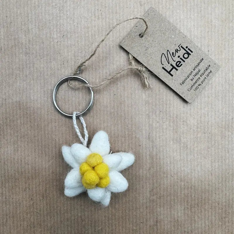 Porte-clé artisanal Edelweiss New Heidi en feutrine blanche et jaune avec son étiquette.
