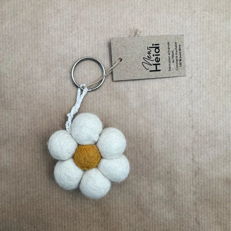 Porte-clé artisanal en forme de fleur blanche New Heidi en feutrine de laine avec cœur jaune.