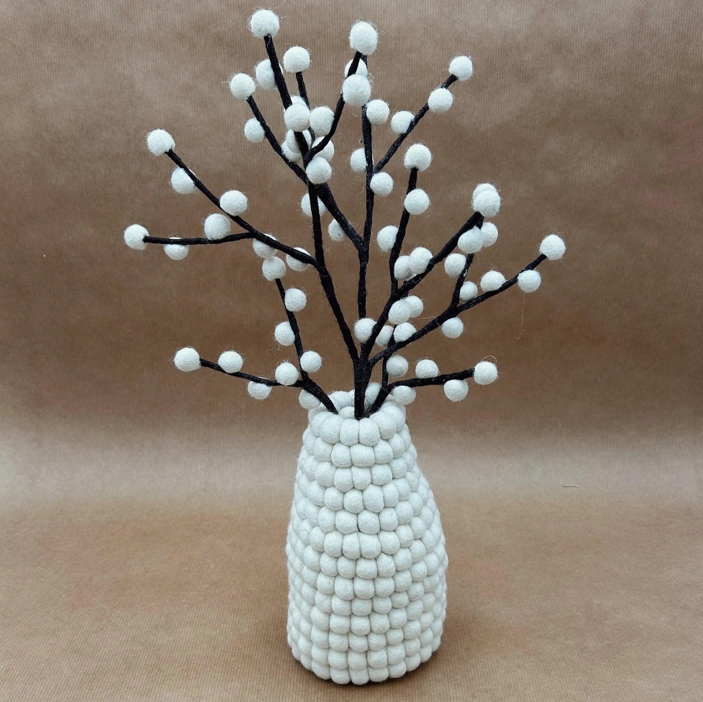 Vase blanc en feutrine de laine artisanale New Heidi avec un bouquet de fleurs colorées.