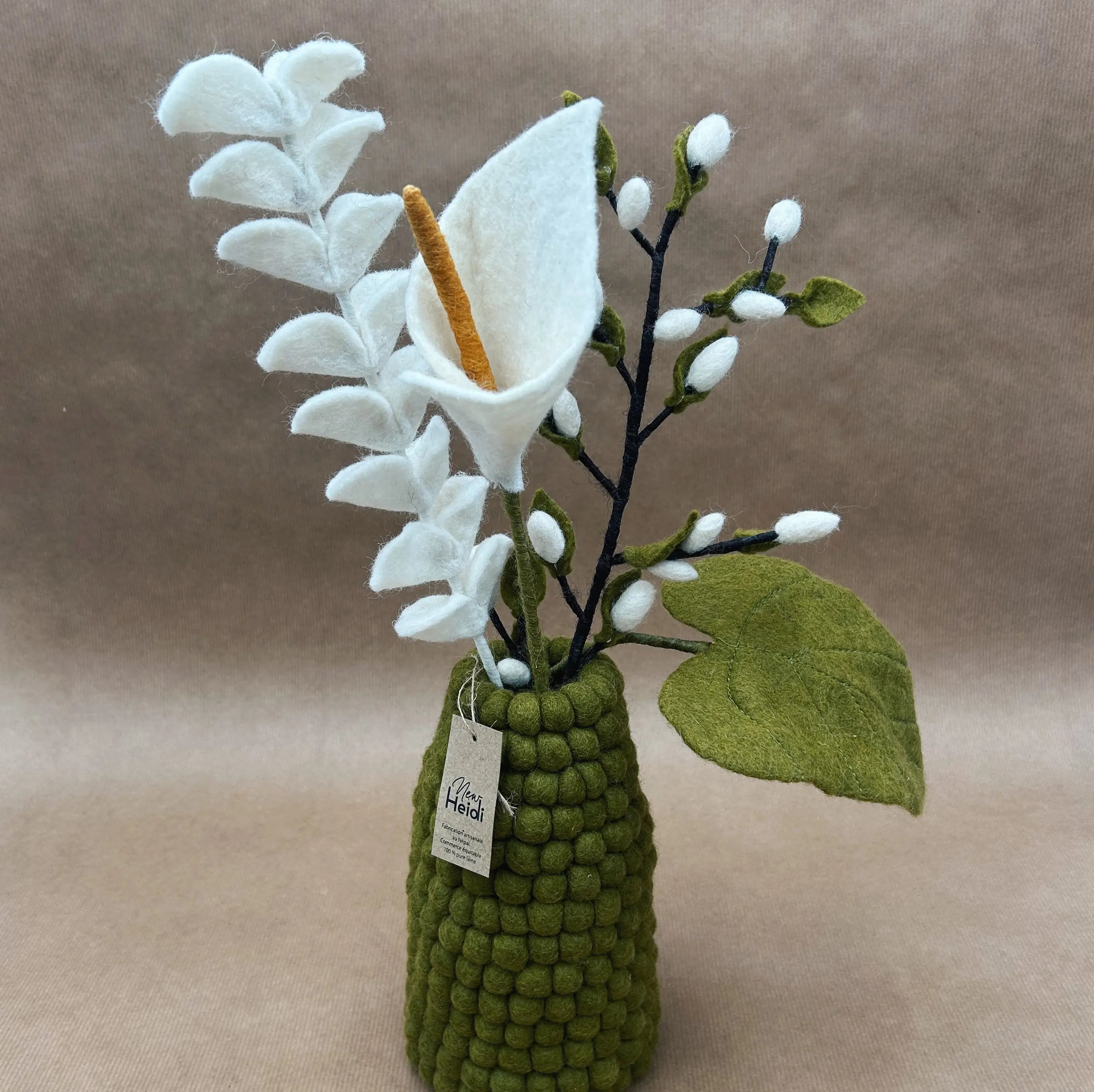 Vase artisanal vert kaki en boules de feutrine New Heidi garni d'un bouquet composé d'un arum et d'eucalyptus en laine.