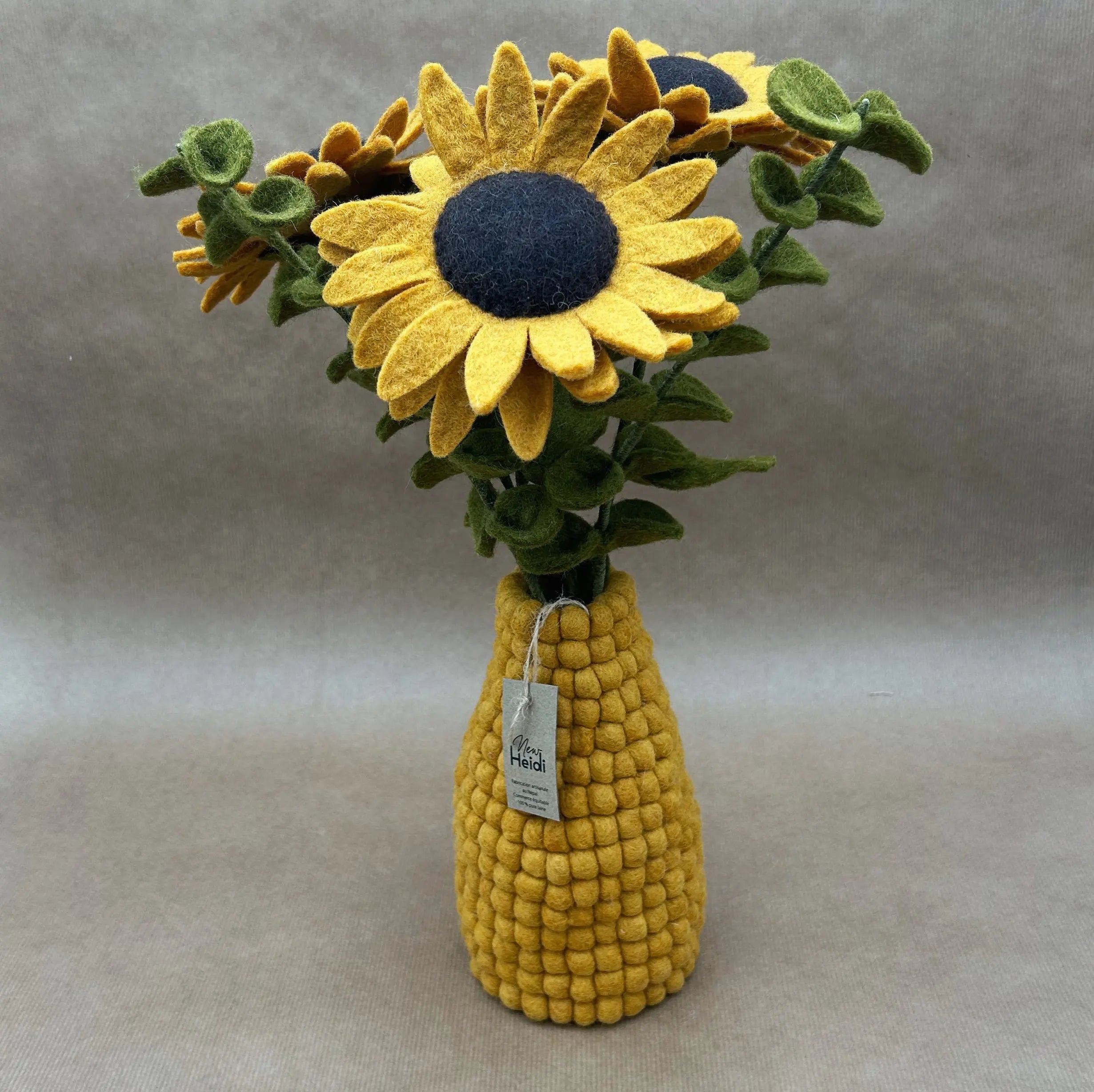 Vase artisanal jaune moutarde en boules de feutrine New Heidi garni d'un bouquet de tournesols en laine.
